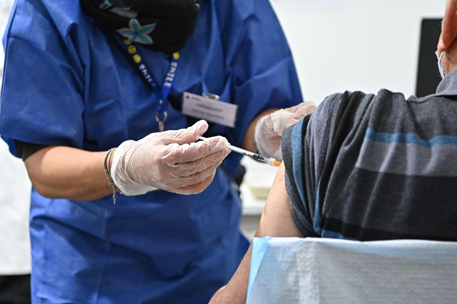 Una enfermera vacuna a un hombre