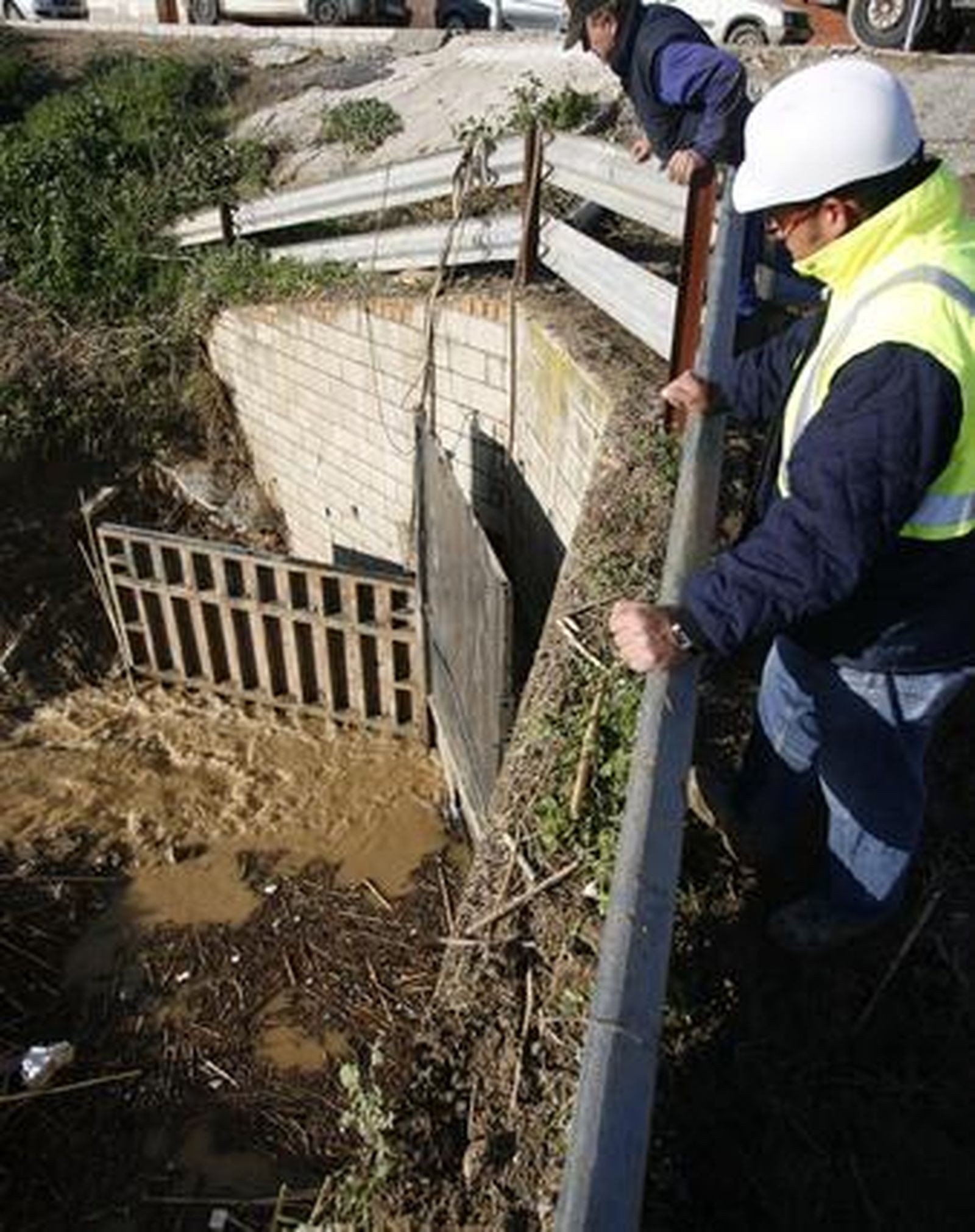 Los trabajadores refuerzan la compuerta para evitar nuevas inundaciones en Écija ante la previsión de lluvias.

Foto: Antonio Pizarro