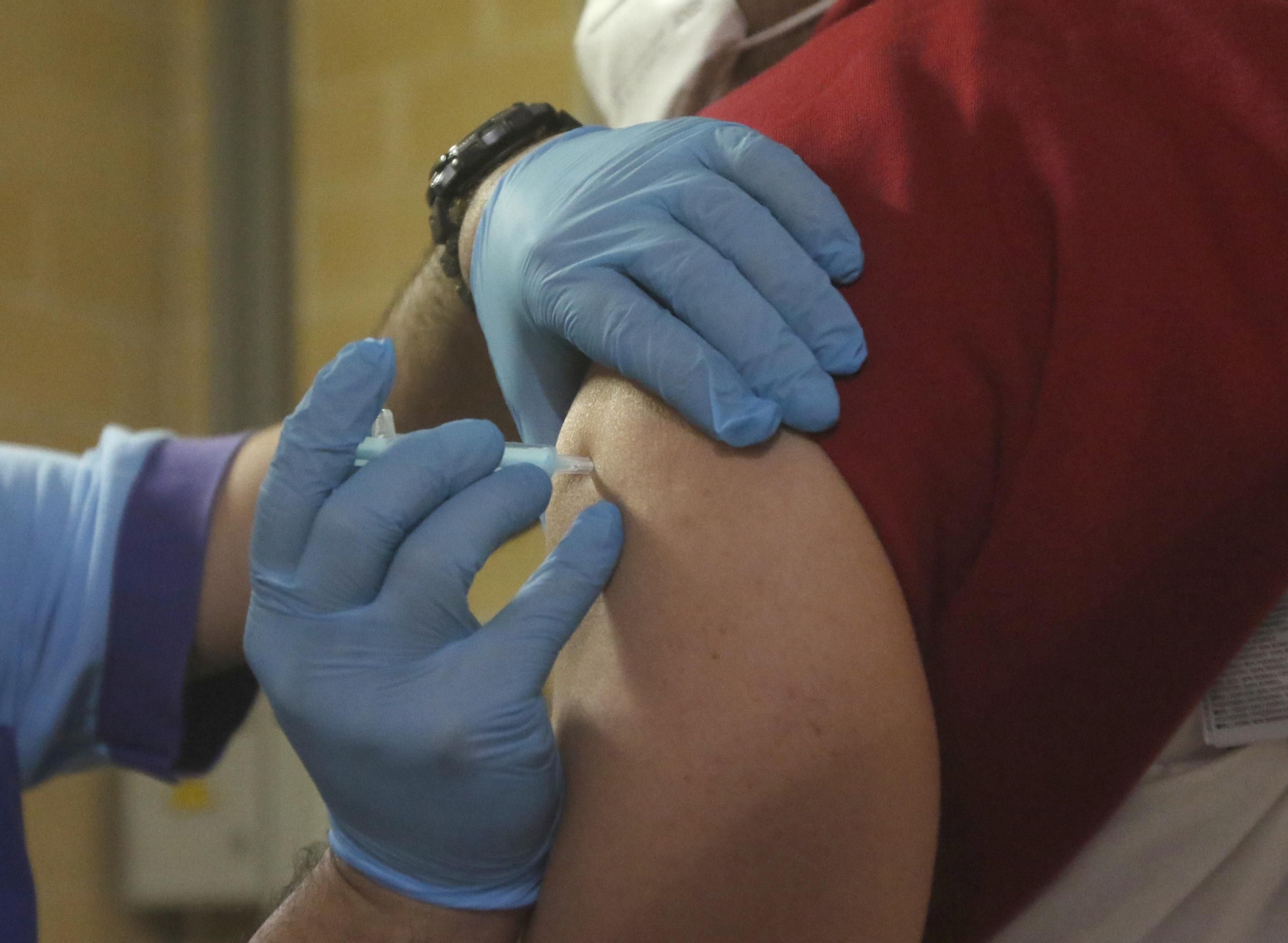 Un sanitario administra una vacuna del covid.