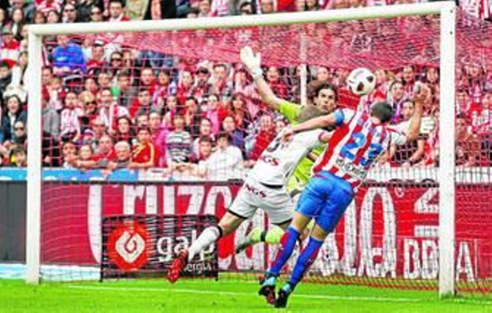 Barral cabecea un balón ante los osasunistas Ricardo López y Nacho Monreal.