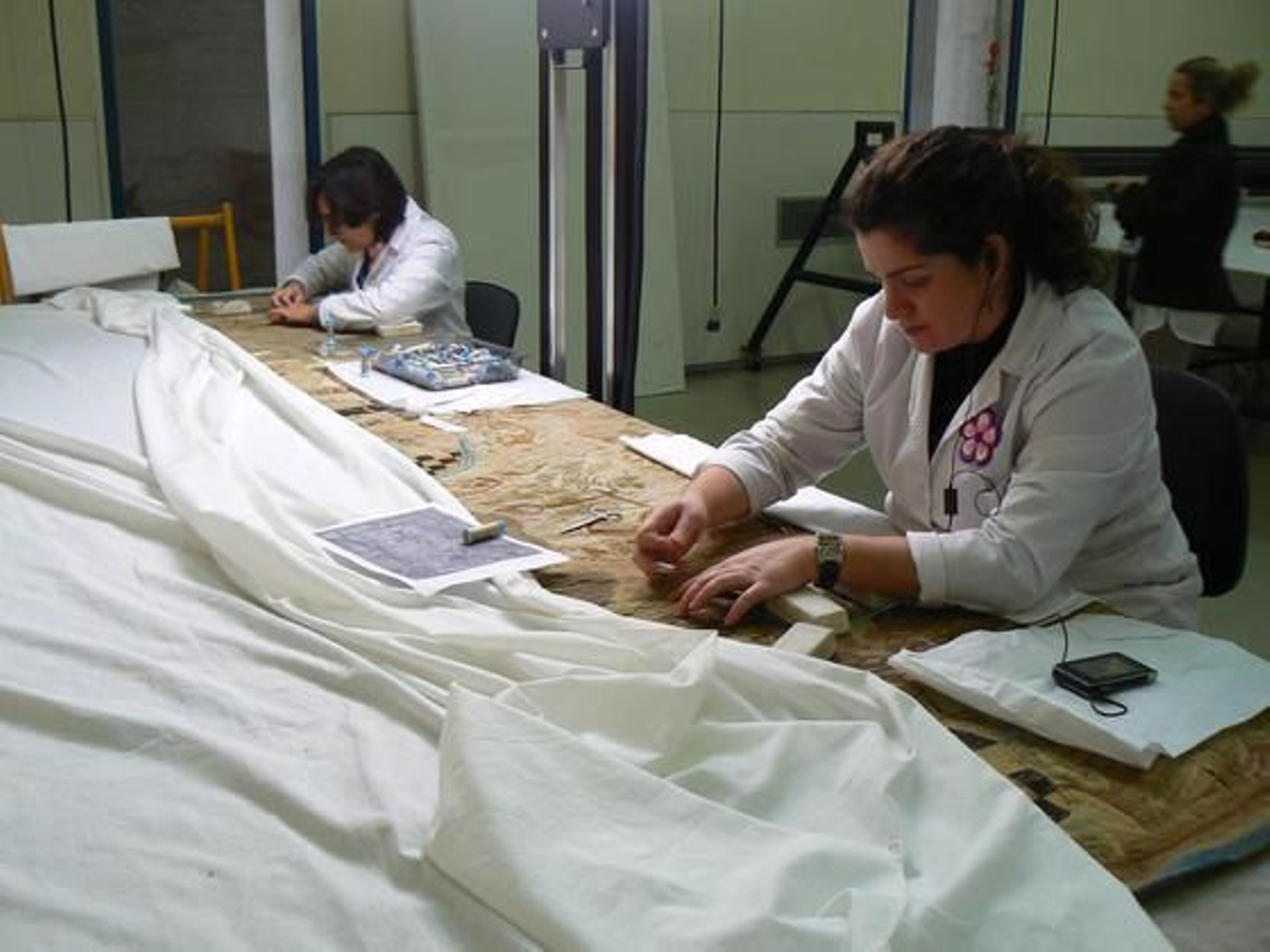 Trabajadoras del taller textil restaurando un tapiz.

Foto: Ruesga Bono
