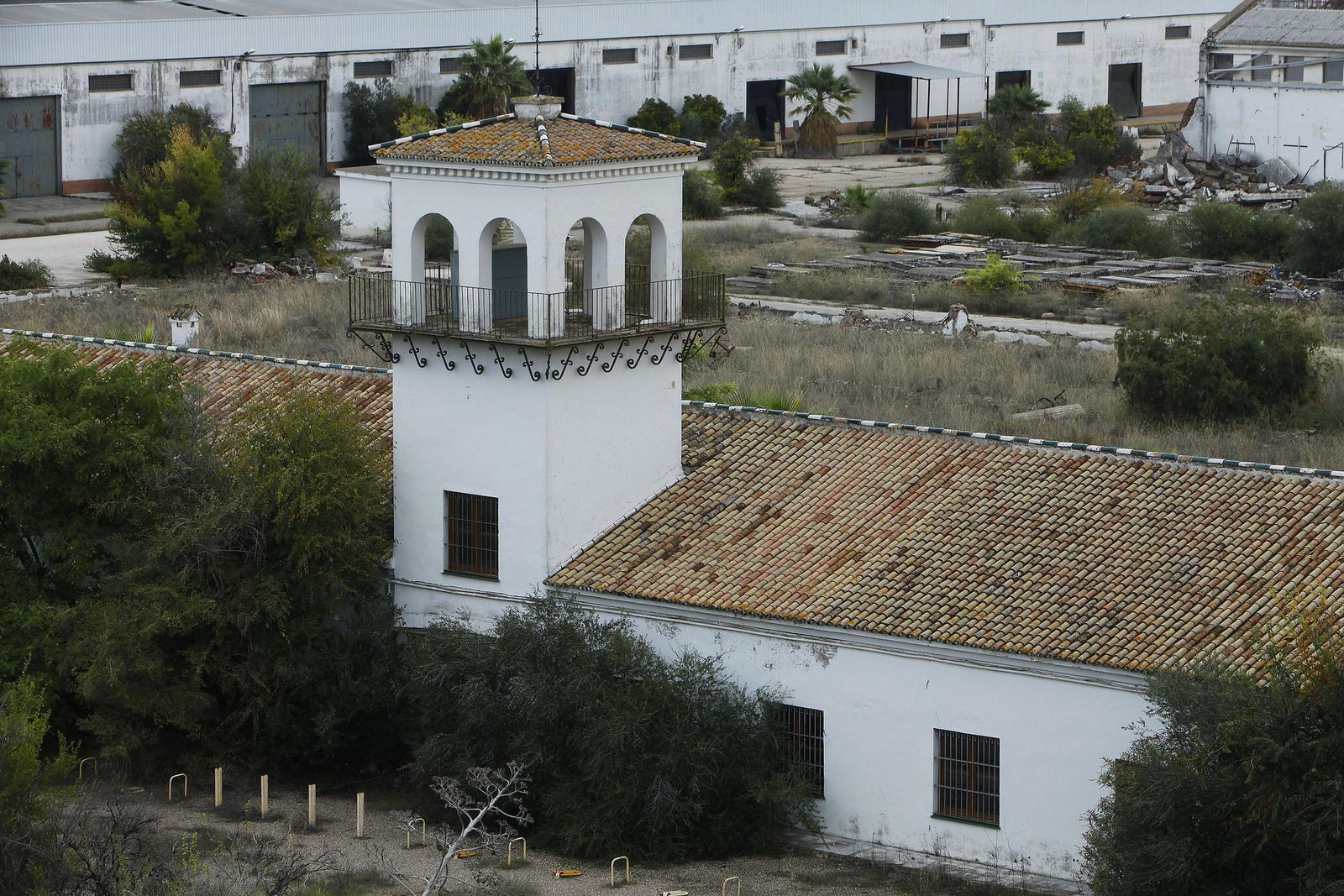 Fachada principal de  la  antigua algodonera  de  Alcosa, con las  viviendas del barrio al fondo.