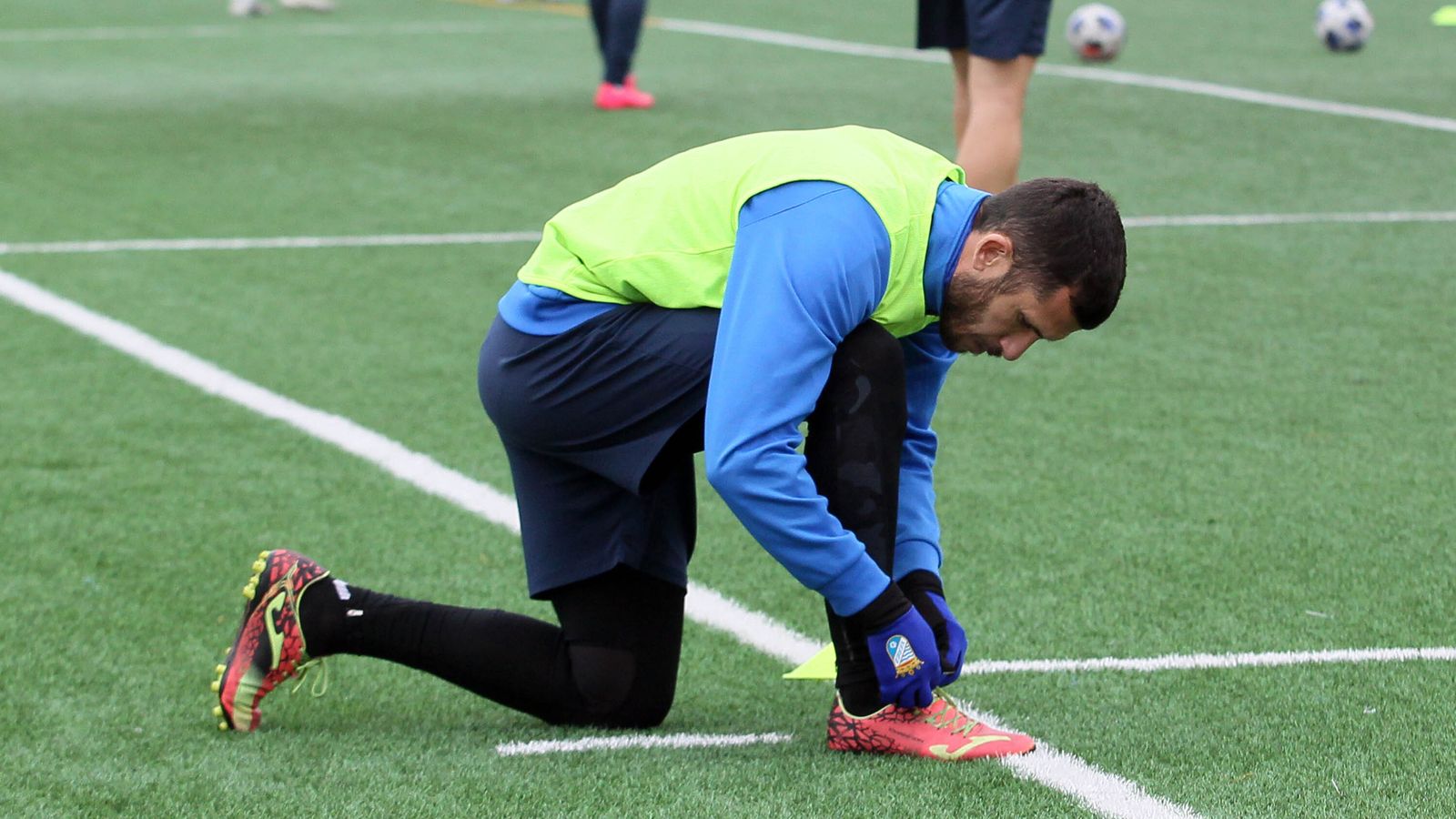 Álex Colorado se ata la bota izquierda antes de iniciar el entrenamiento.