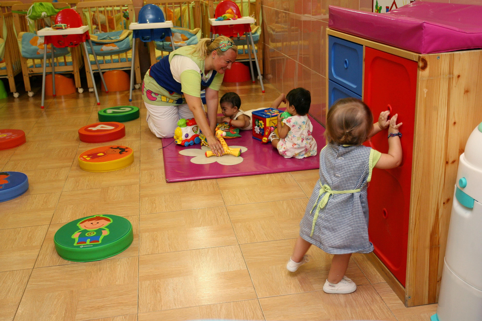 Una maestra juega con los más pequeños de su escuela infantil.