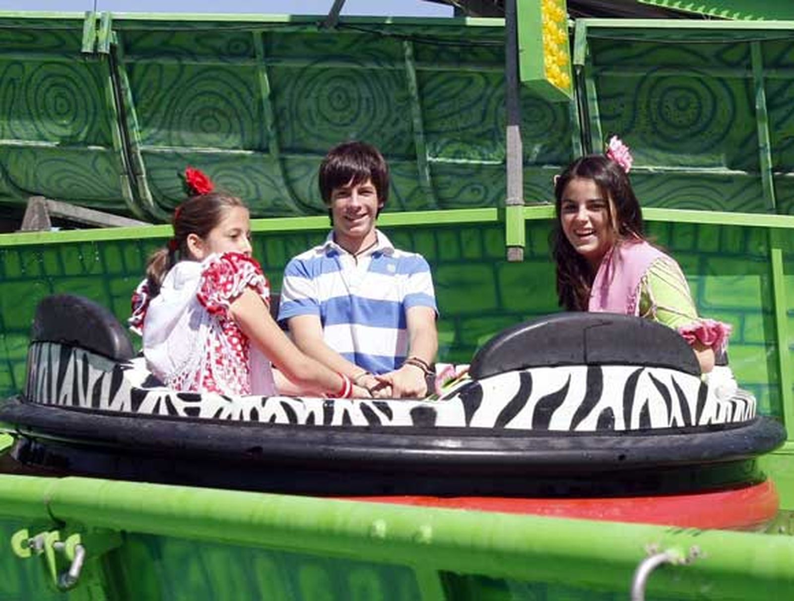 Tres niños en una de las atracciones de feria

Foto: Fito Carreto