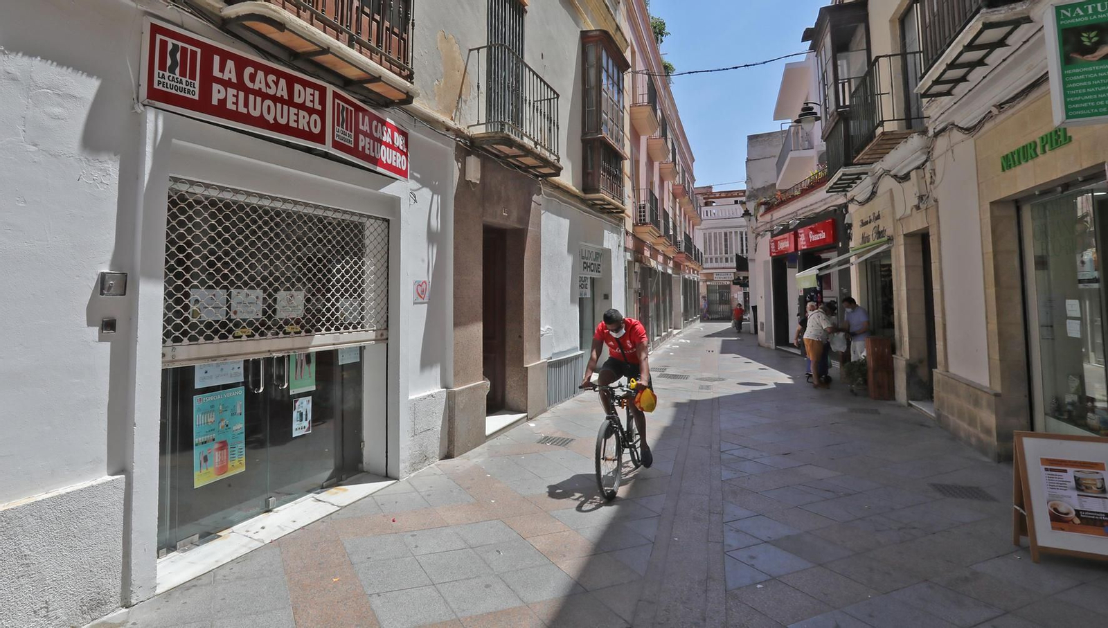 La Casa del Peluquero, con la persiana entreabierta en pleno horario comercial.