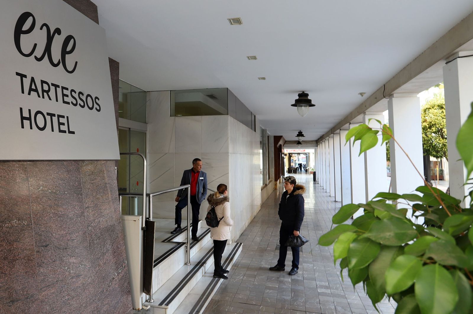 Personas a la entrada  de un Hotel en Huelva.