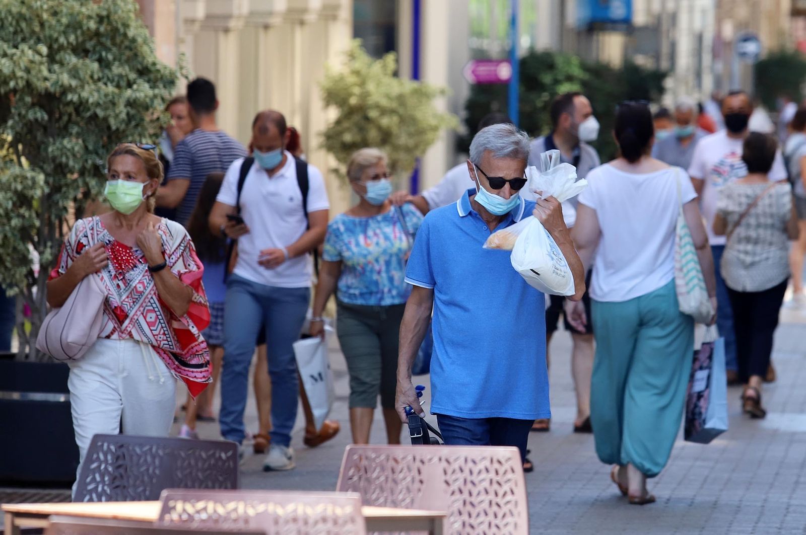 Varias personas pasean con mascarilla por la ciudad.