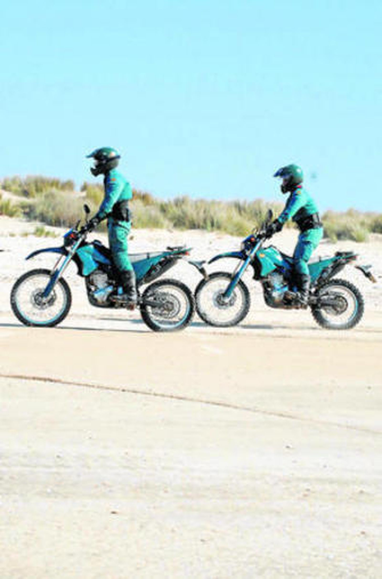 Dos agentes del Seprona, recorriendo en moto la playa de Doñana.