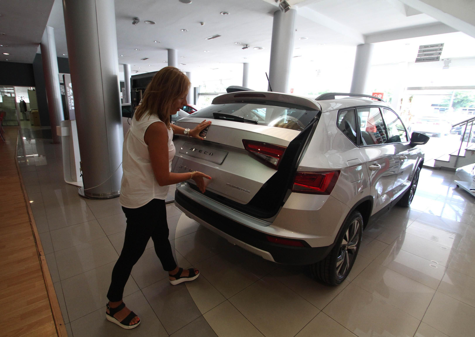 Imagen de archivo de una compradora inspeccionando un vehículo en el concesionario