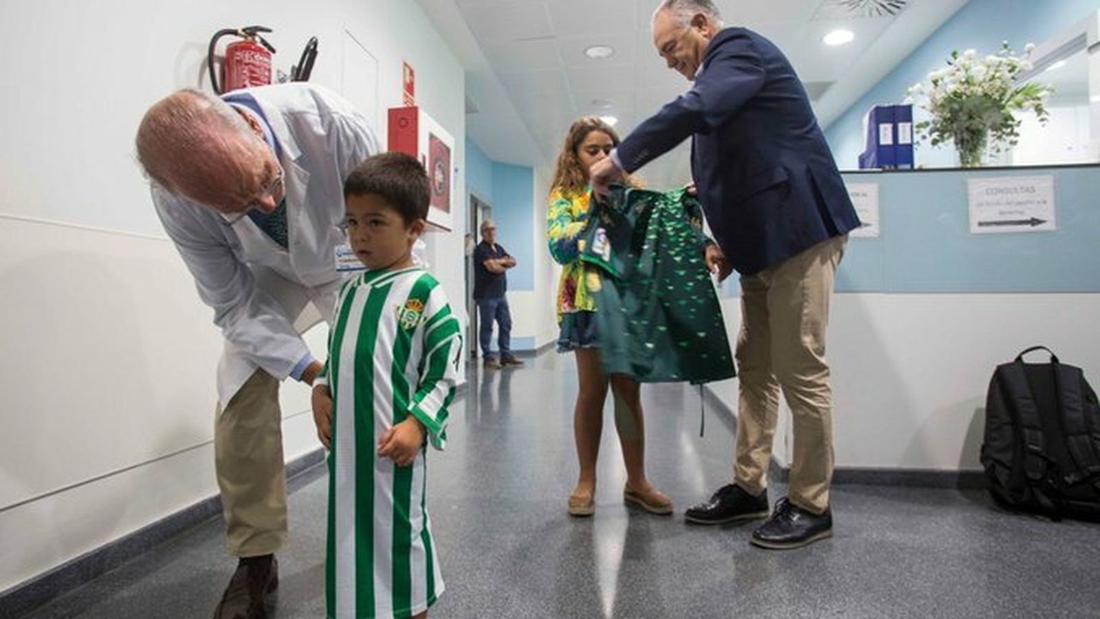 Rafael Gordillo entrega a una pequeña una de las batas.