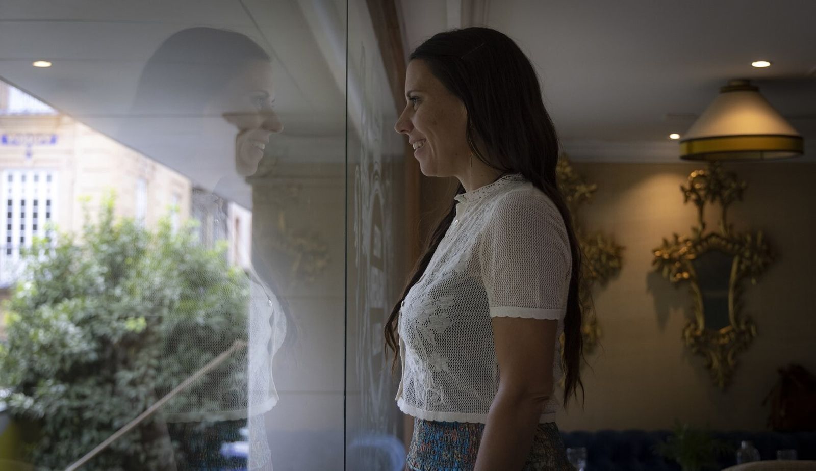 La escritora Rut Nieves mira a través de la ventana del Hotel Inglaterra.