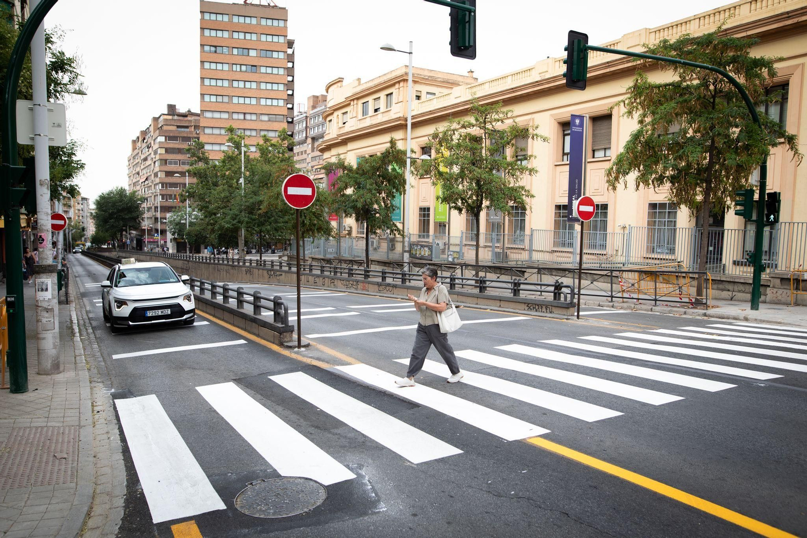 Una mujer camina por el recién pintado paso de peatones.