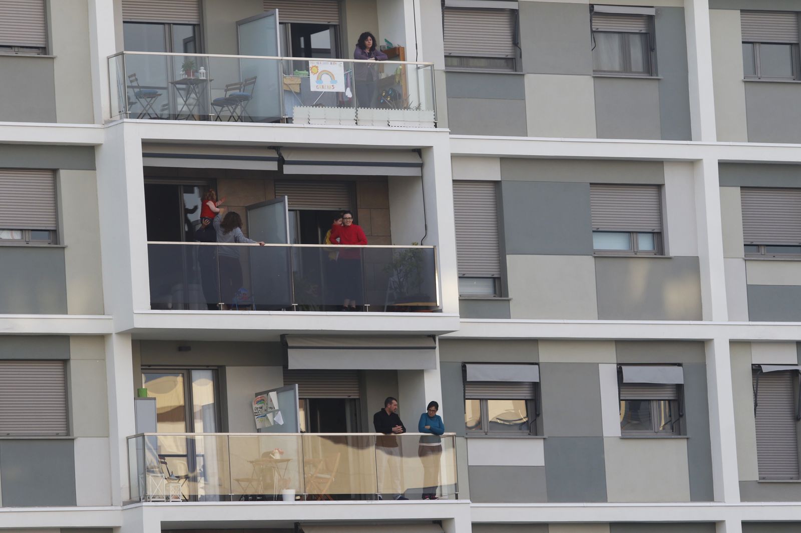 Varias personas, asomadas a sus balcones durante el periodo de confinamiento.