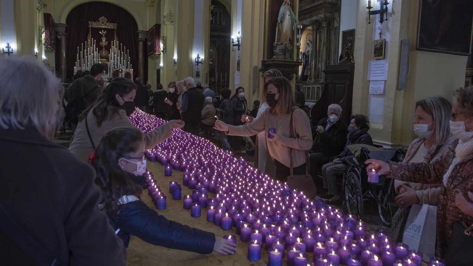 Las devotas le ponen velas al Cautivo de San Ildefonso.