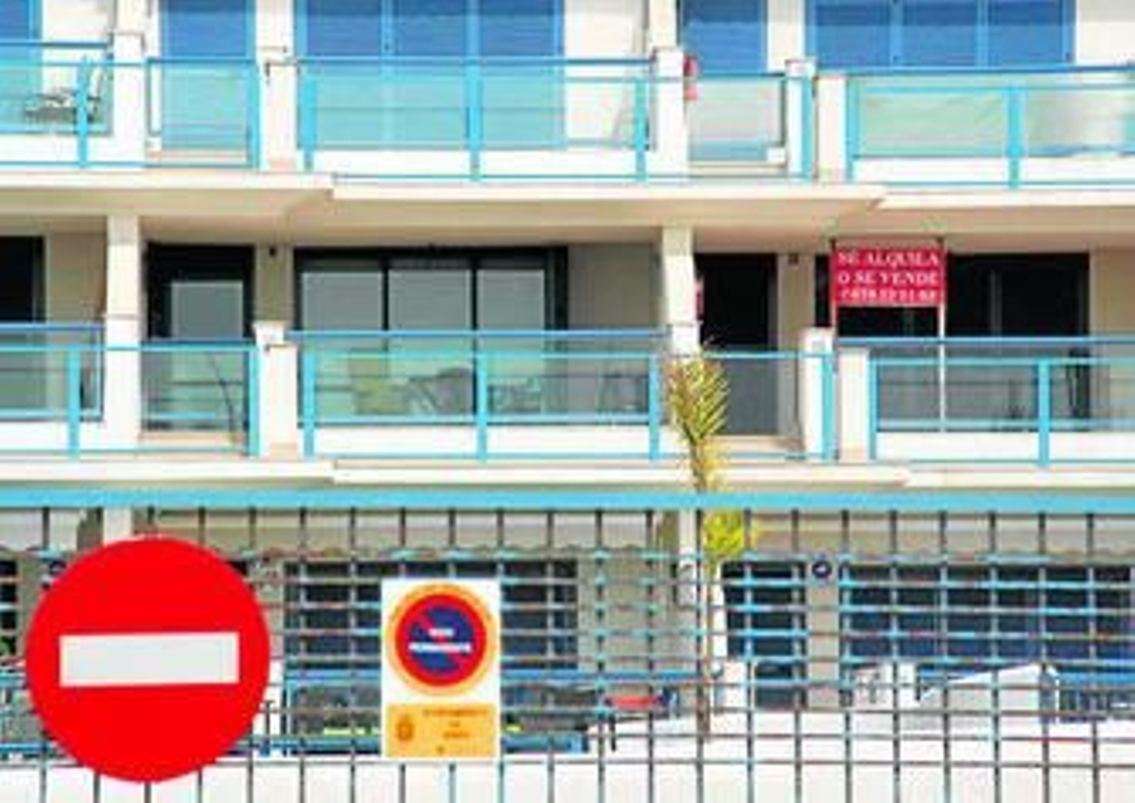 Carteles en venta y terrazas vacías en un bloque de pisos.