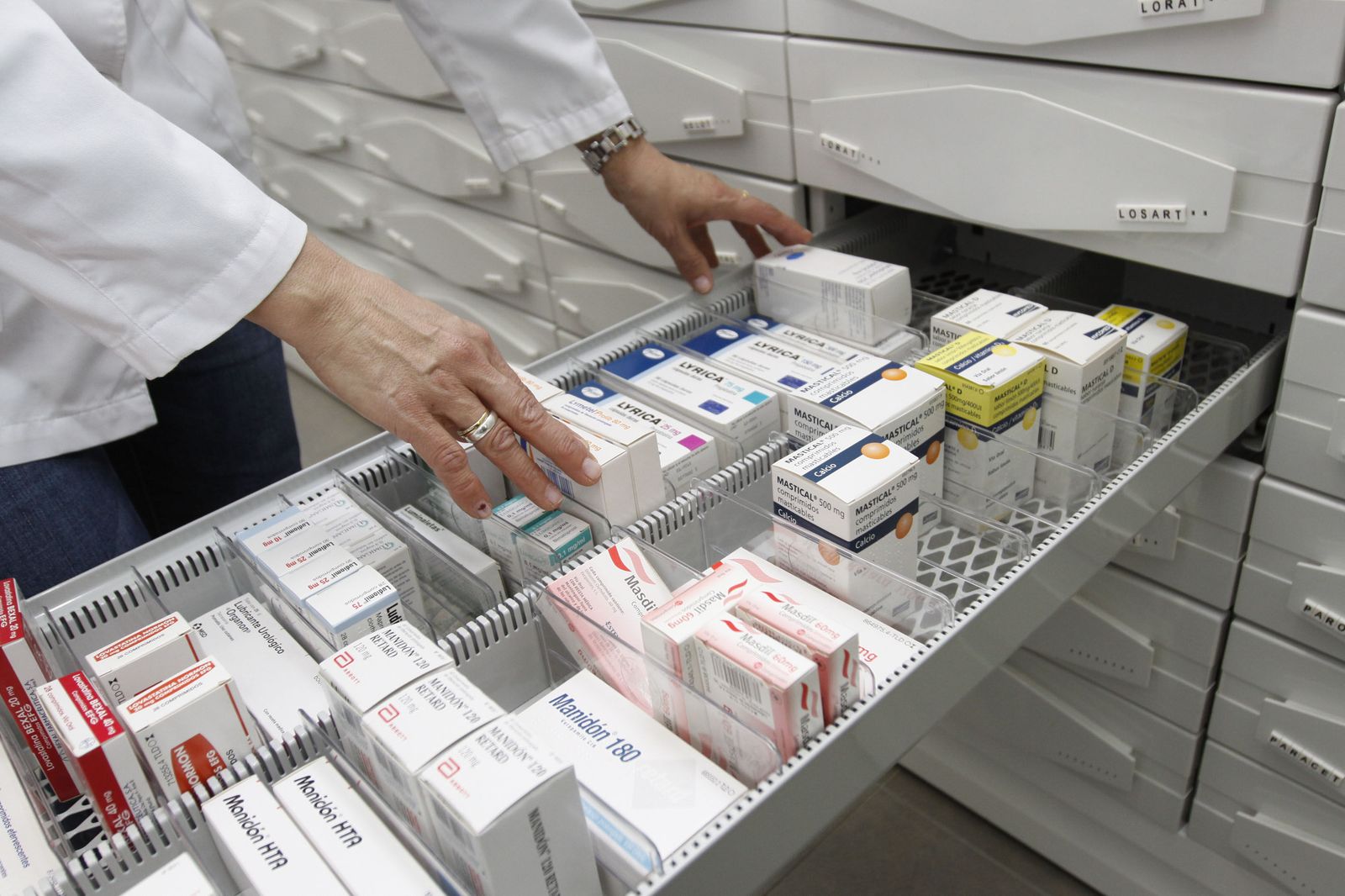 Un farmacéutico revisa los medicamentos de los que dispone en la botica.