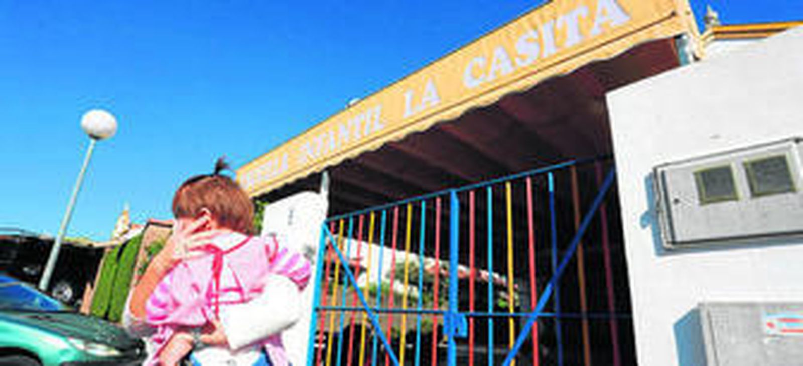 Una madre sale con su hija de 'La Casita' ayer al mediodía.