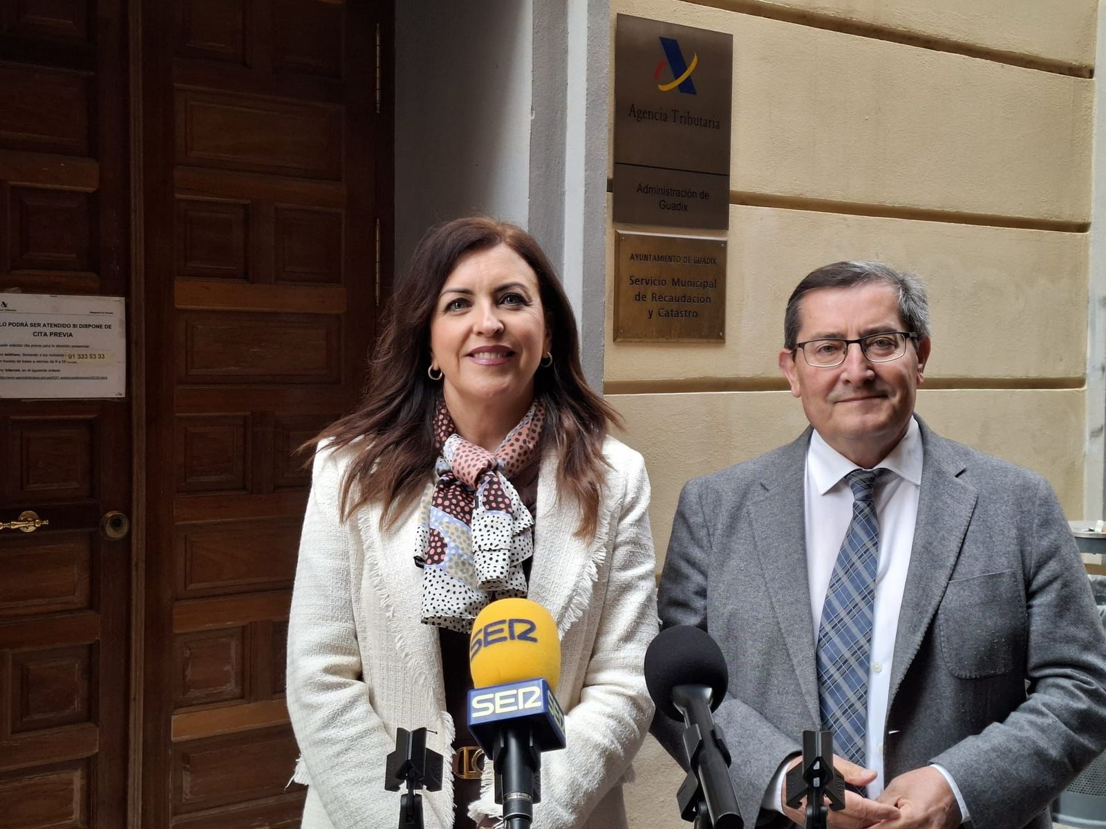 Belén Porcel y Pepe Entrena ante la oficina de la Agencia Tributaria de Guadix