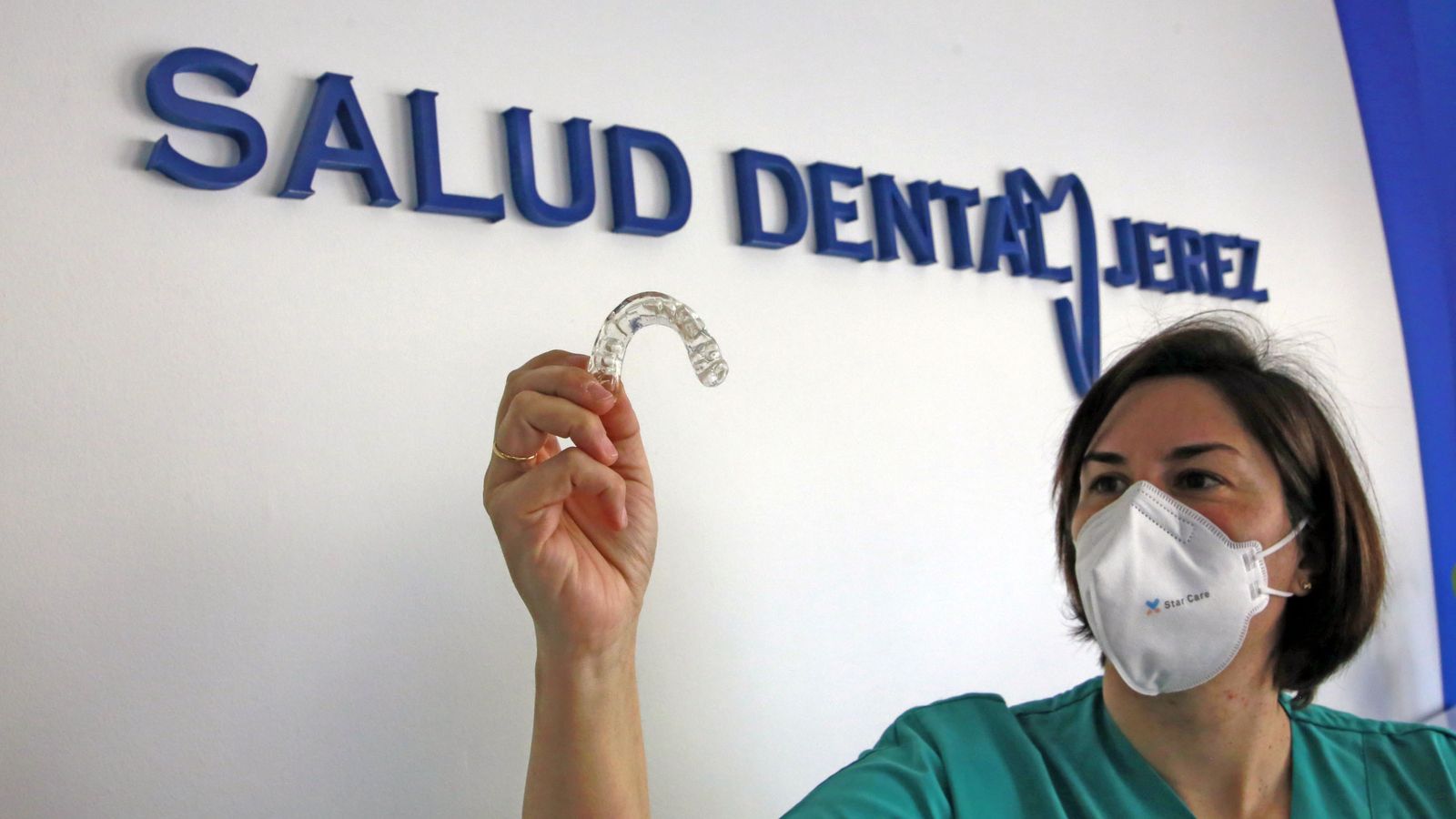 Una dentista sostiene una placa de descarga, cuya aplicación se está disparando.