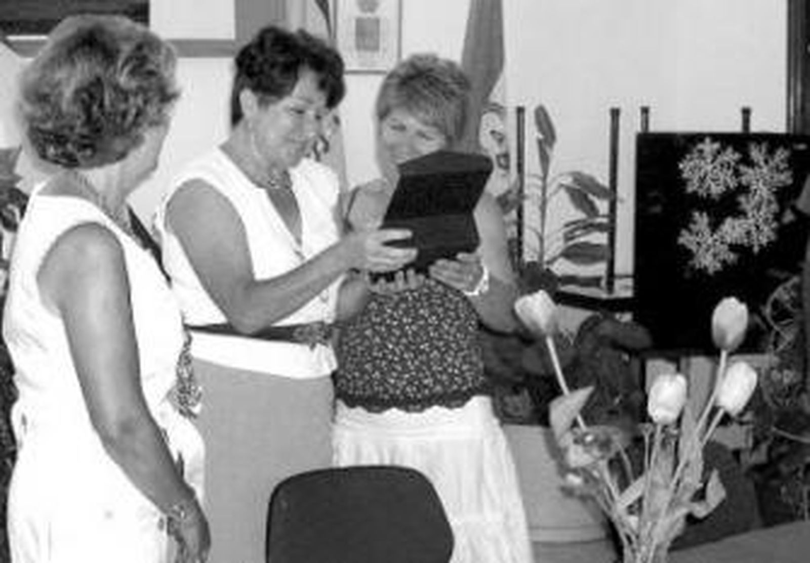 La galardonada como vecina del año recoge la placa.