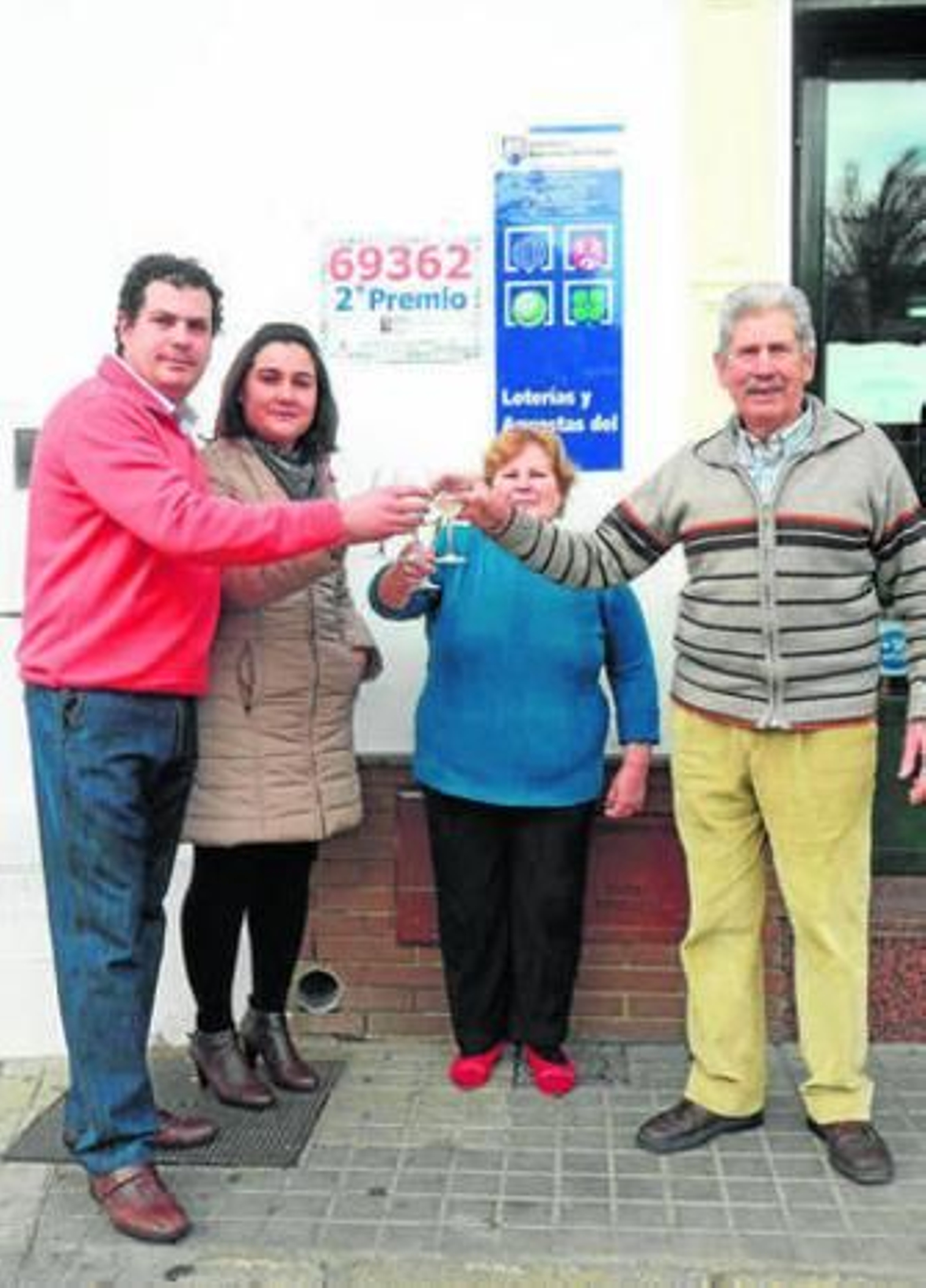 Los  propietarios del Café Bar Museo brindan por el premio y vecinos de Aracena en la administración de lotería, ayer.