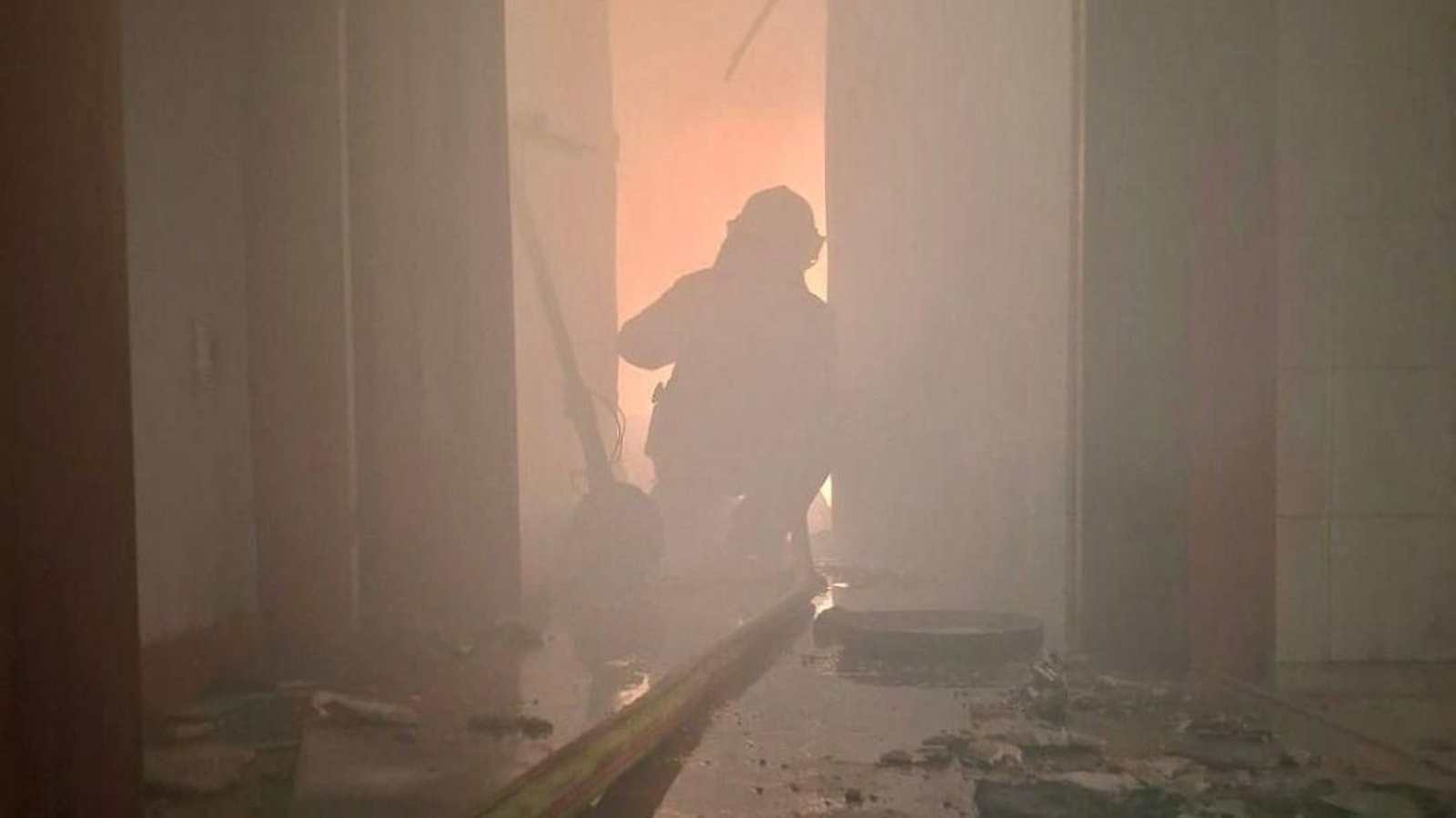 Un bombero trabaja en la extinción de un incendio en una vivienda de la barriada de la Caja de Ahorros, en Chiclana.