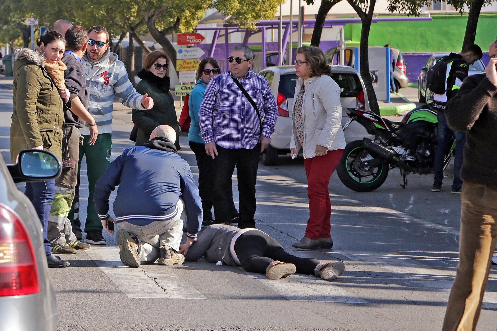 La mujer permanece ayer inmovilizada sobre el asfalto. A la derecha, la moto.