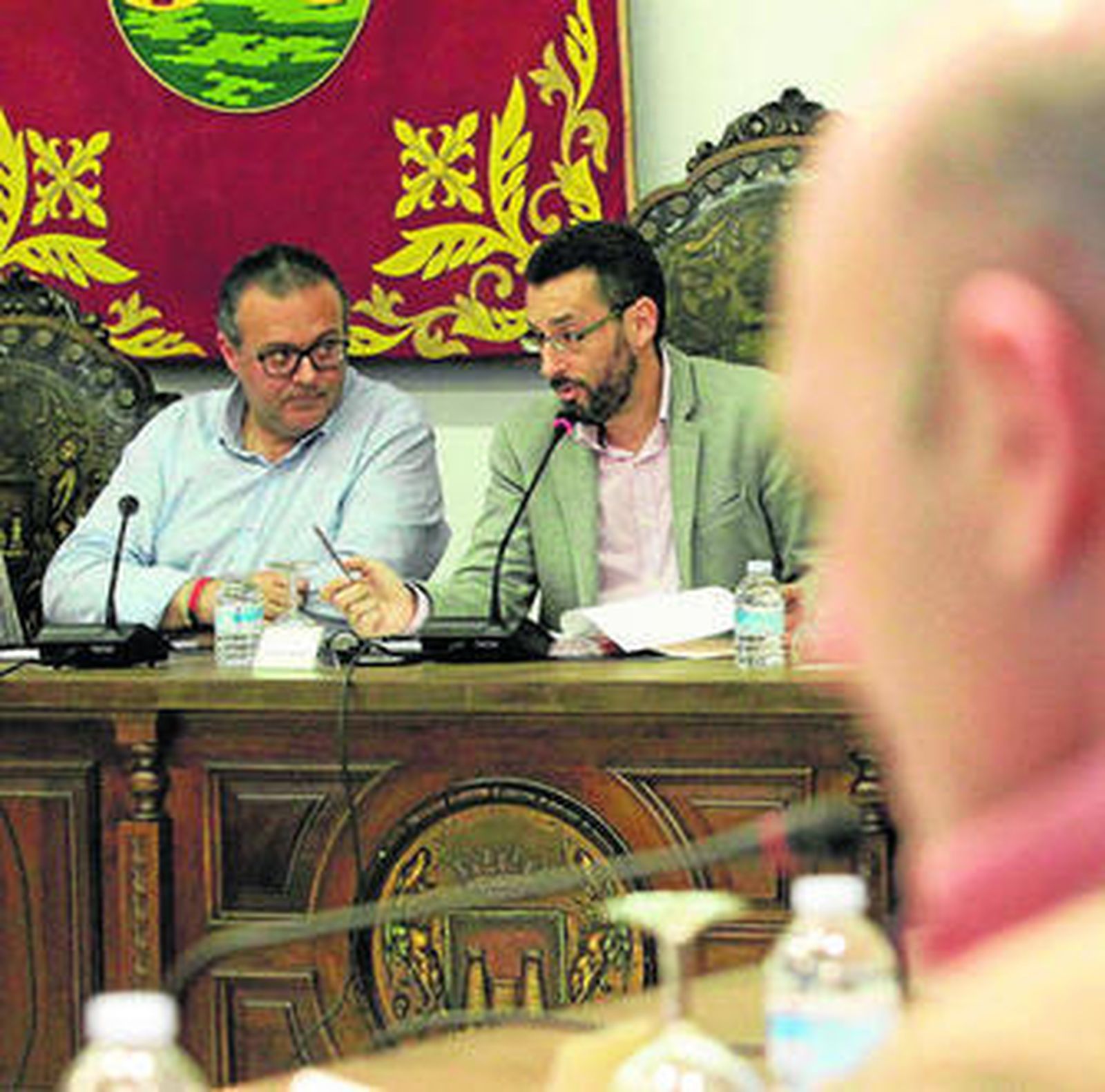 César Escobar, a la izquierda, dialoga con Juan Franco durante un pleno.