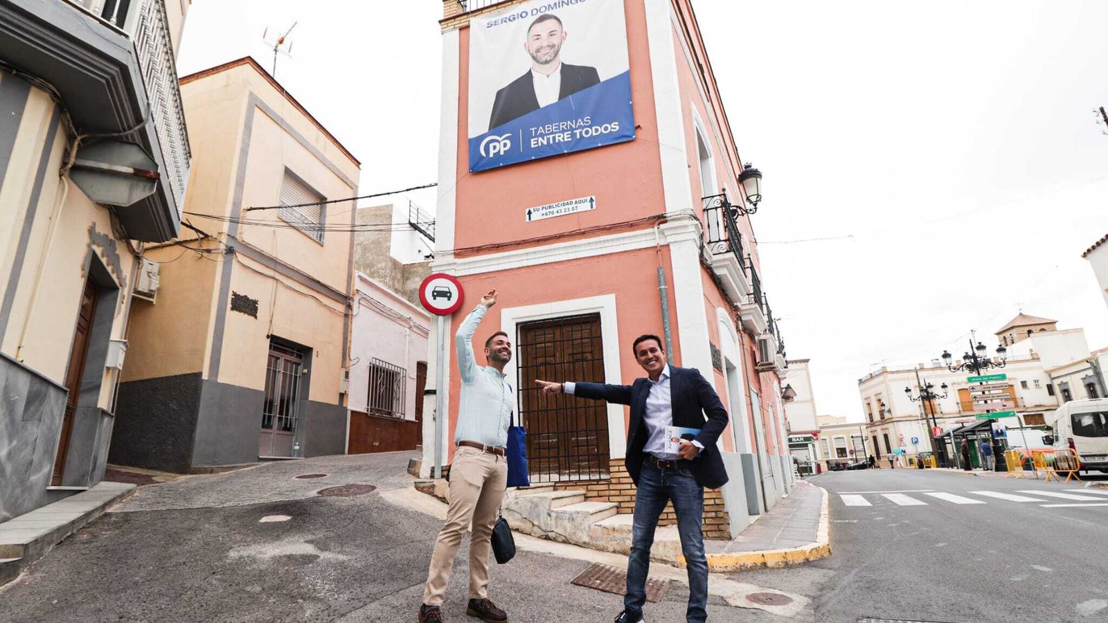 Domínguez y García, junto a un cartel del candidato del PP.