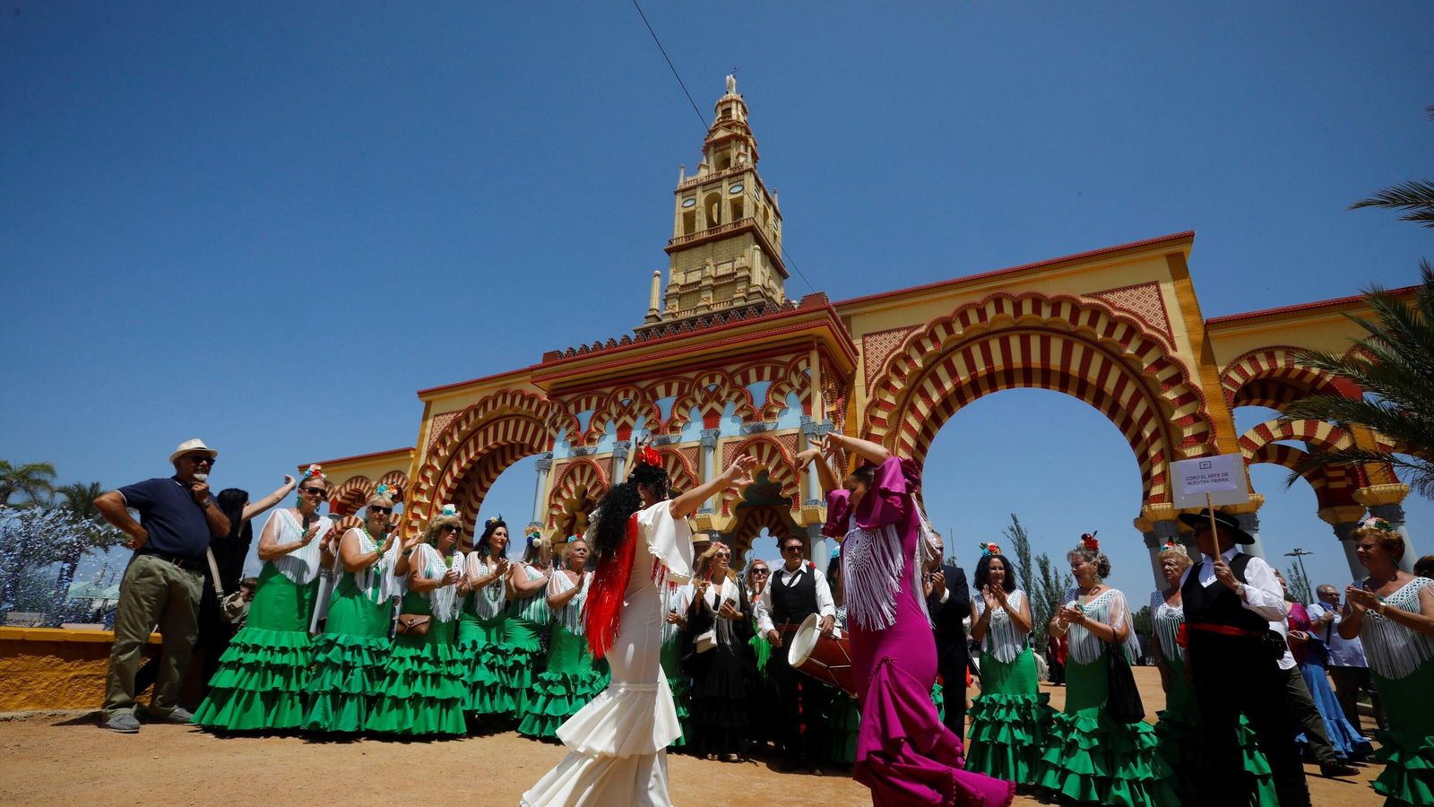 Dos mujeres bailan sevillanas al son de unos de los muchos coros rocieros que tomaron ayer El Arenal.