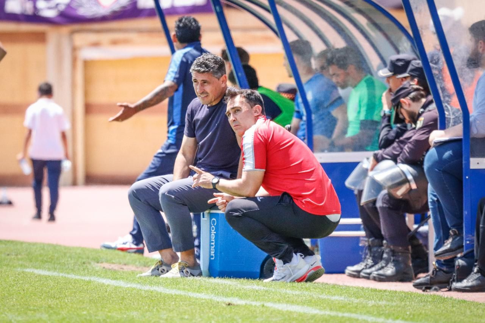 Roberto Peragón charla con su ayudante Pedro Velasco en el estadio Santo Domingo.