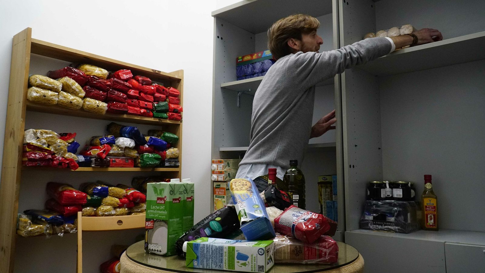 Candi Sánchez, voluntario de Cáritas de la Parroquia de Santa Ana, organiza los alimentos recibidos en su alamacen.