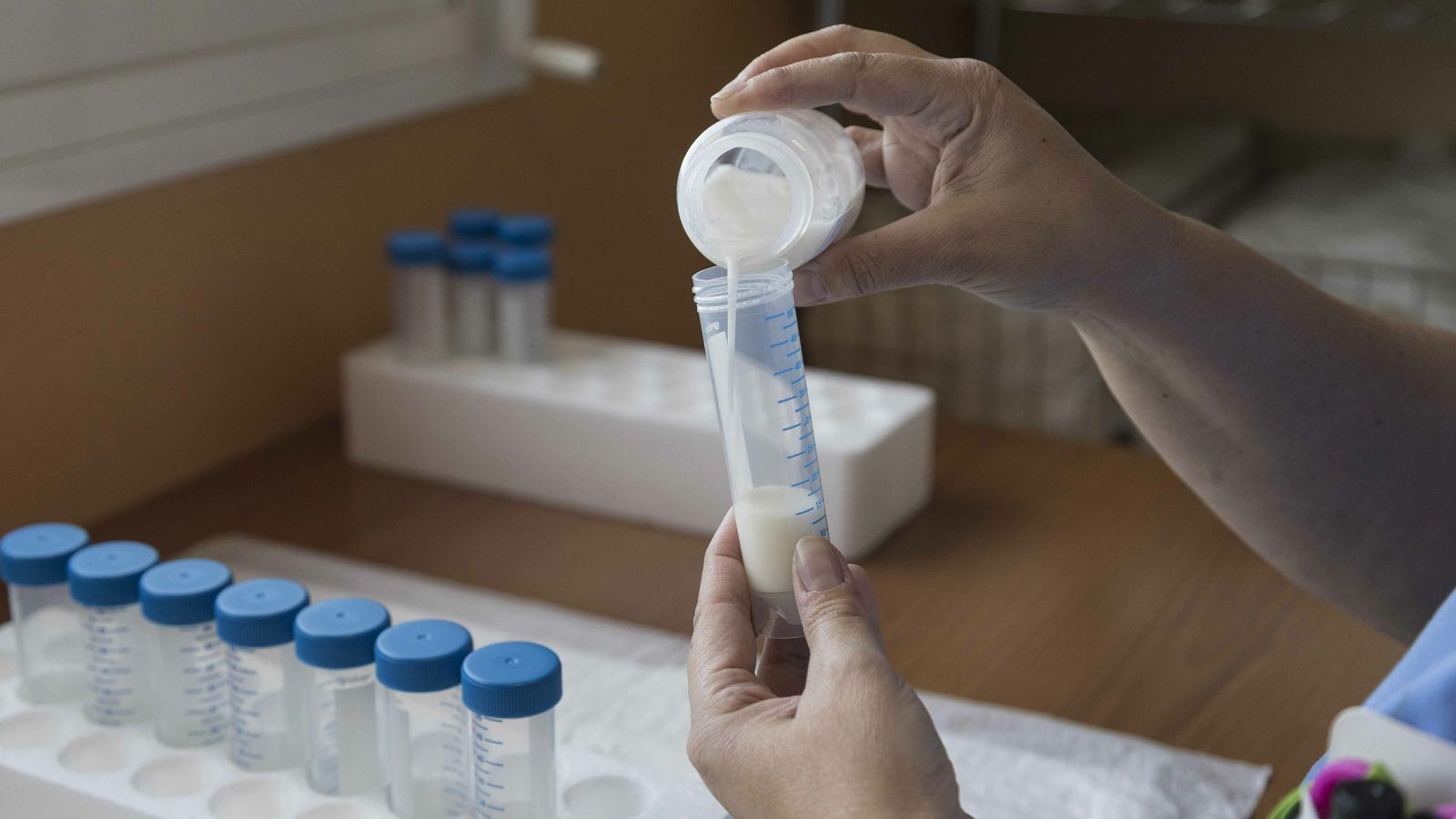 Una enfermera prepara una dosis de leche para un prematuro en el Valme.