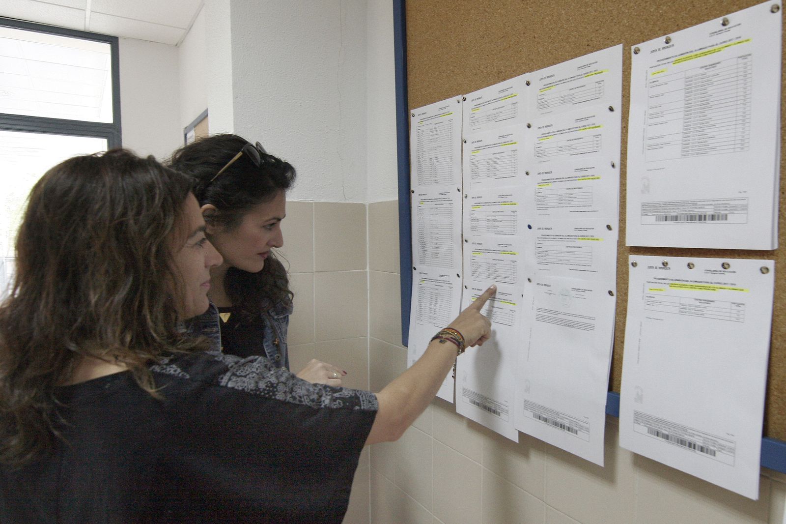 Dos personas consultando las listas en años anteriores.