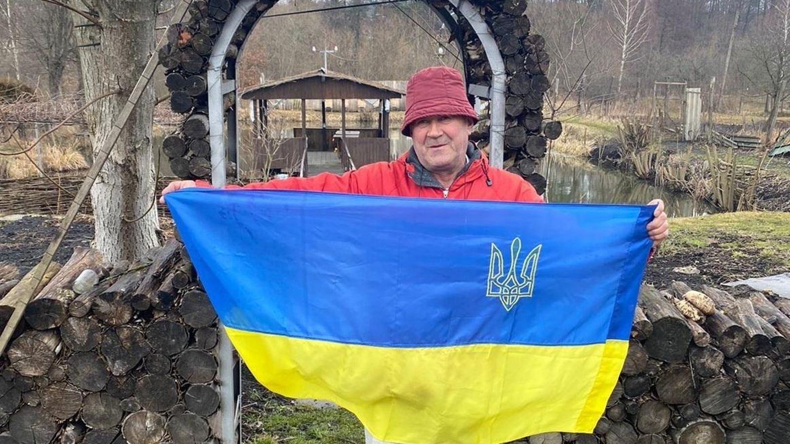 El padre de Maxim posa con una bandera de Ucrania.