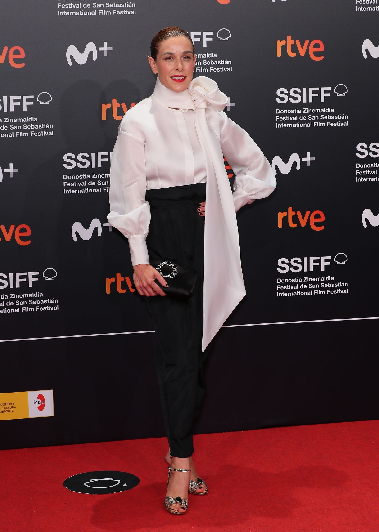 Raquel Sánchez Silva lleva blusa satinada de manga larga con una gran lazada en el cuello de la firma Marcos Luengo y pantalones de Jorge Vázquez.