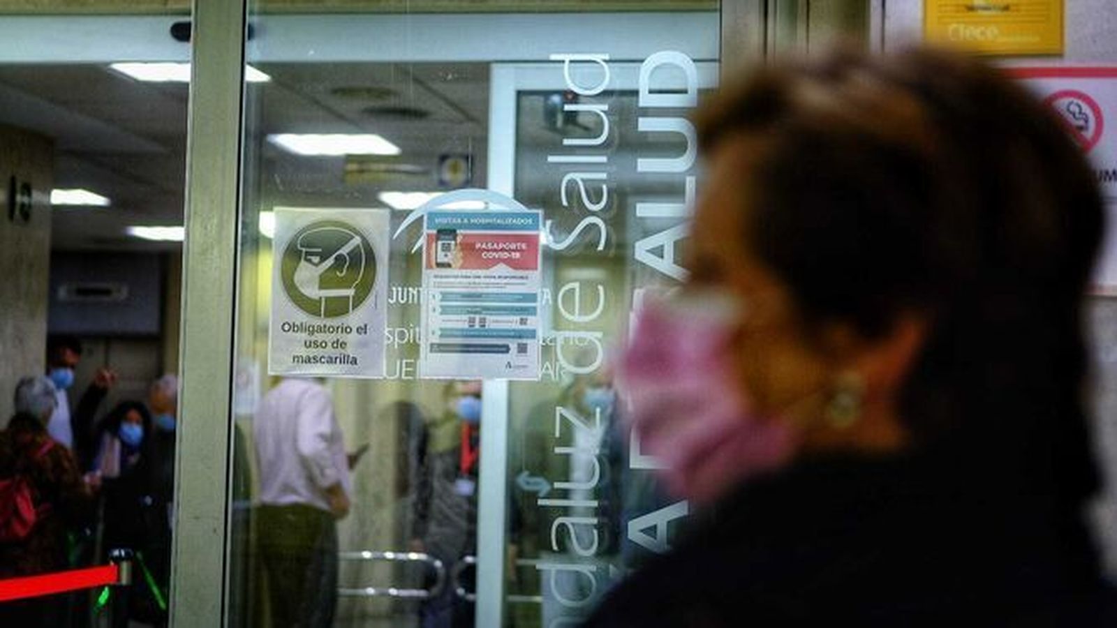 Una mujer con mascarilla a las puertas del hospital Puerta del Mar