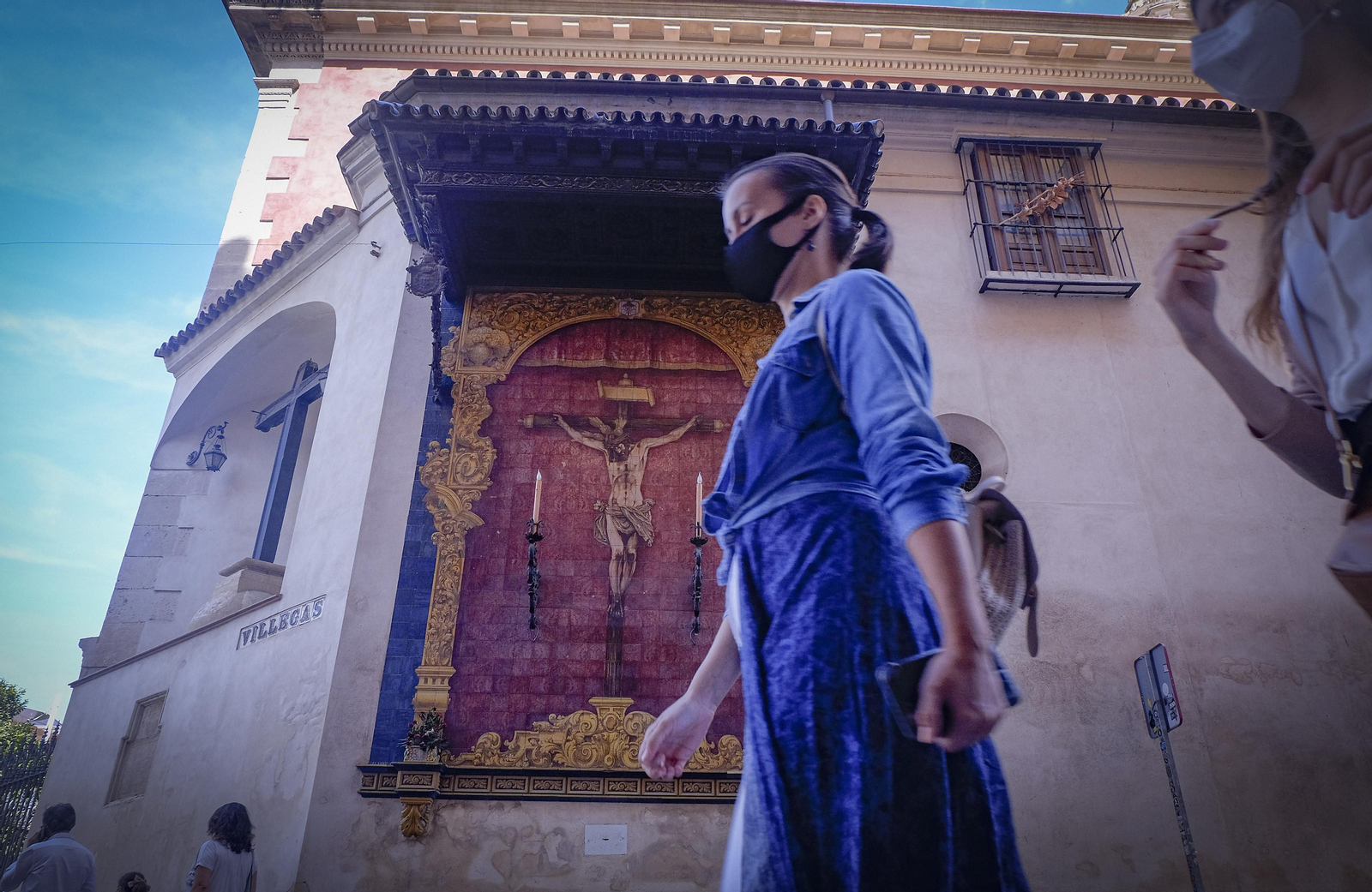 Un mujer pasea con mascarilla por Sevilla.
