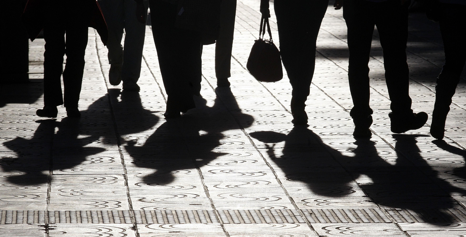 La silueta de varias personas por una calle de Málaga.