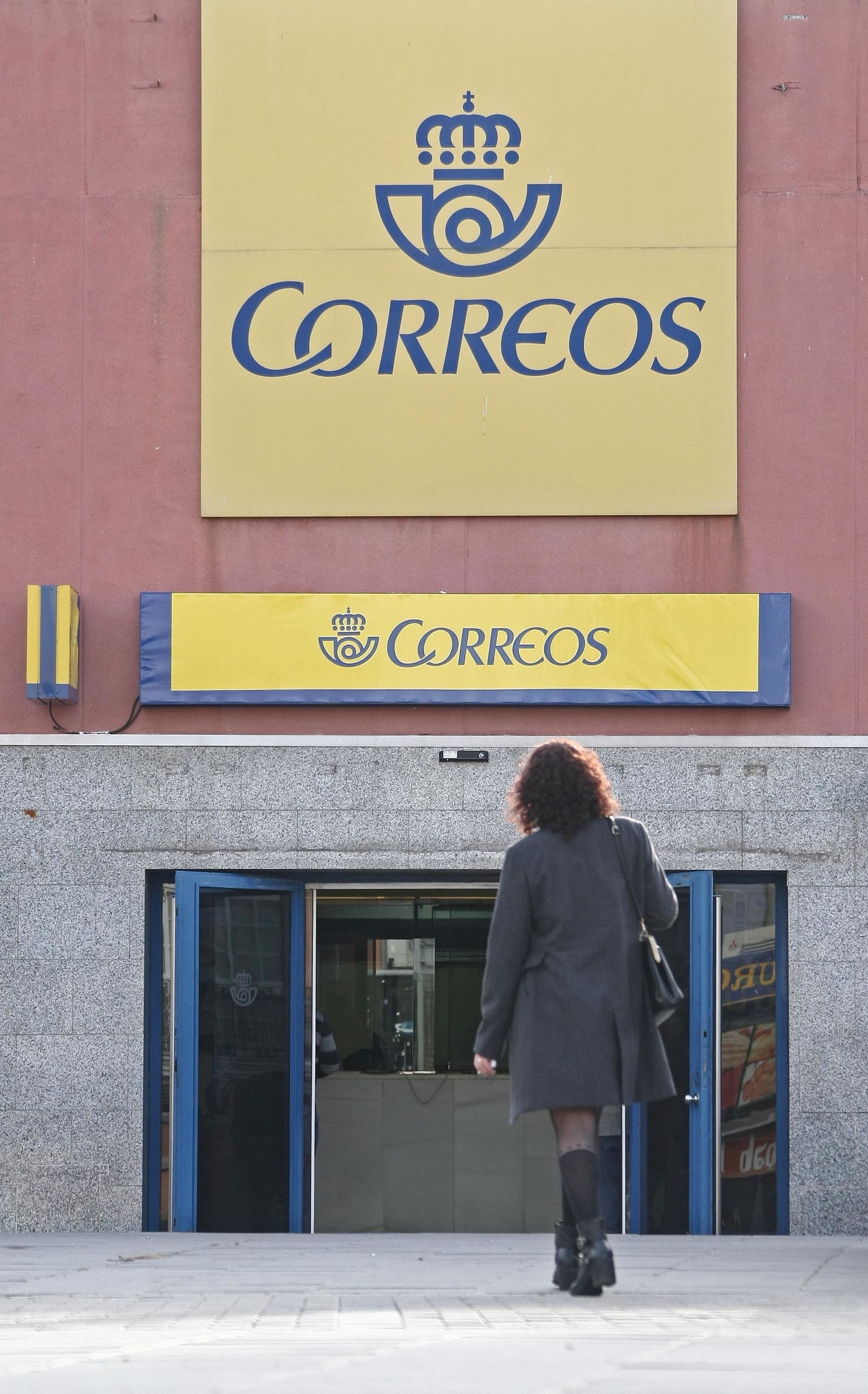 Una mujer se encamina hacia una oficina de Correos.