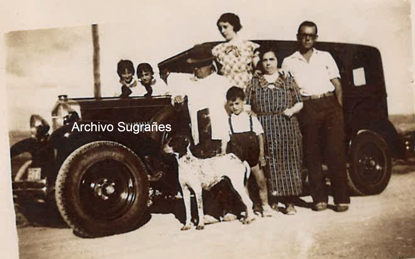 Una familia con su coche en una época en la que son más populares.