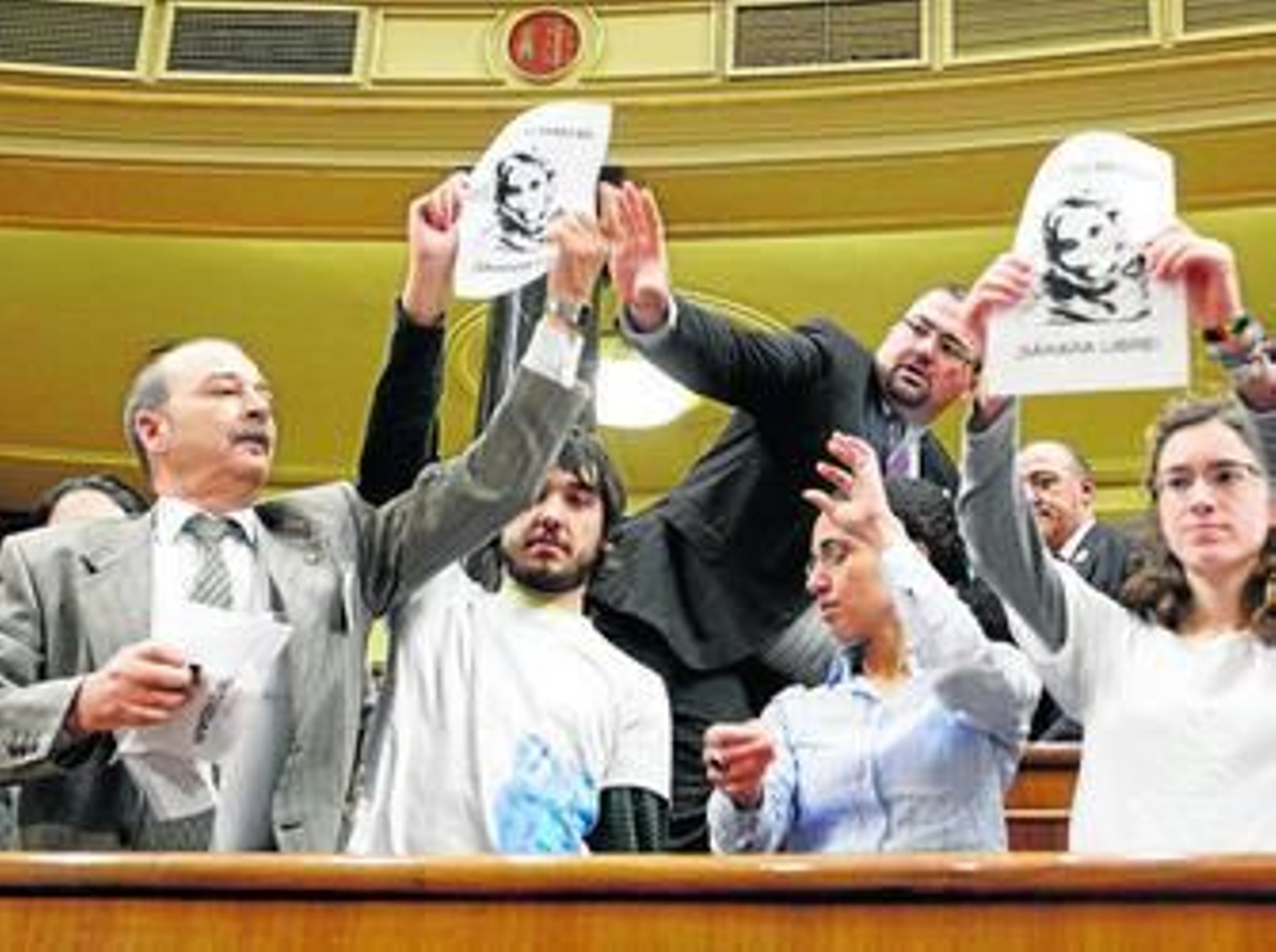 Ujieres y personal de seguridad del Congreso retiran carteles con el rostro de la activista Haidar durante la jornada de puertas abiertas.