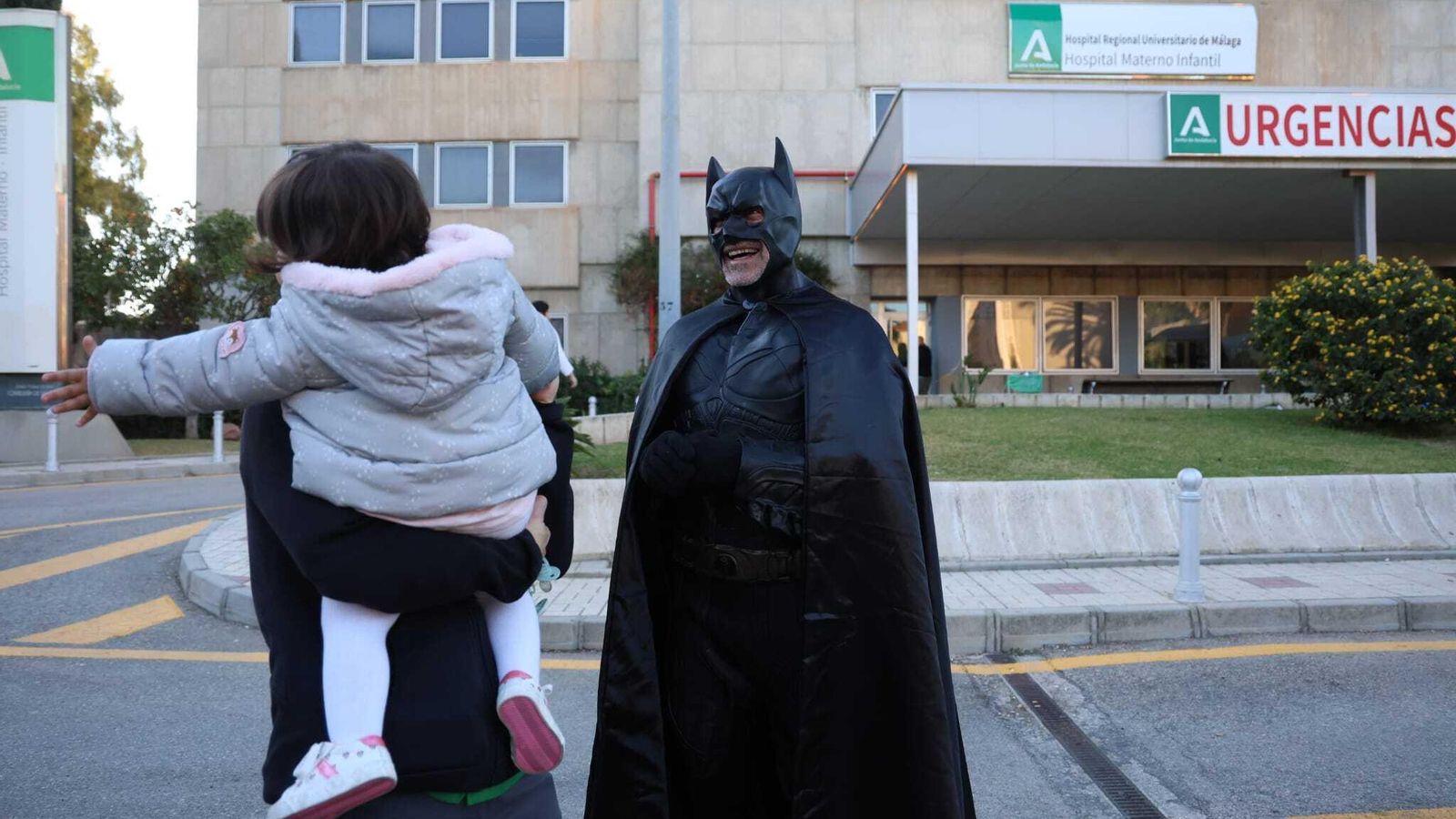 Batman saludando a un niño delante de la puerta de urgencias.