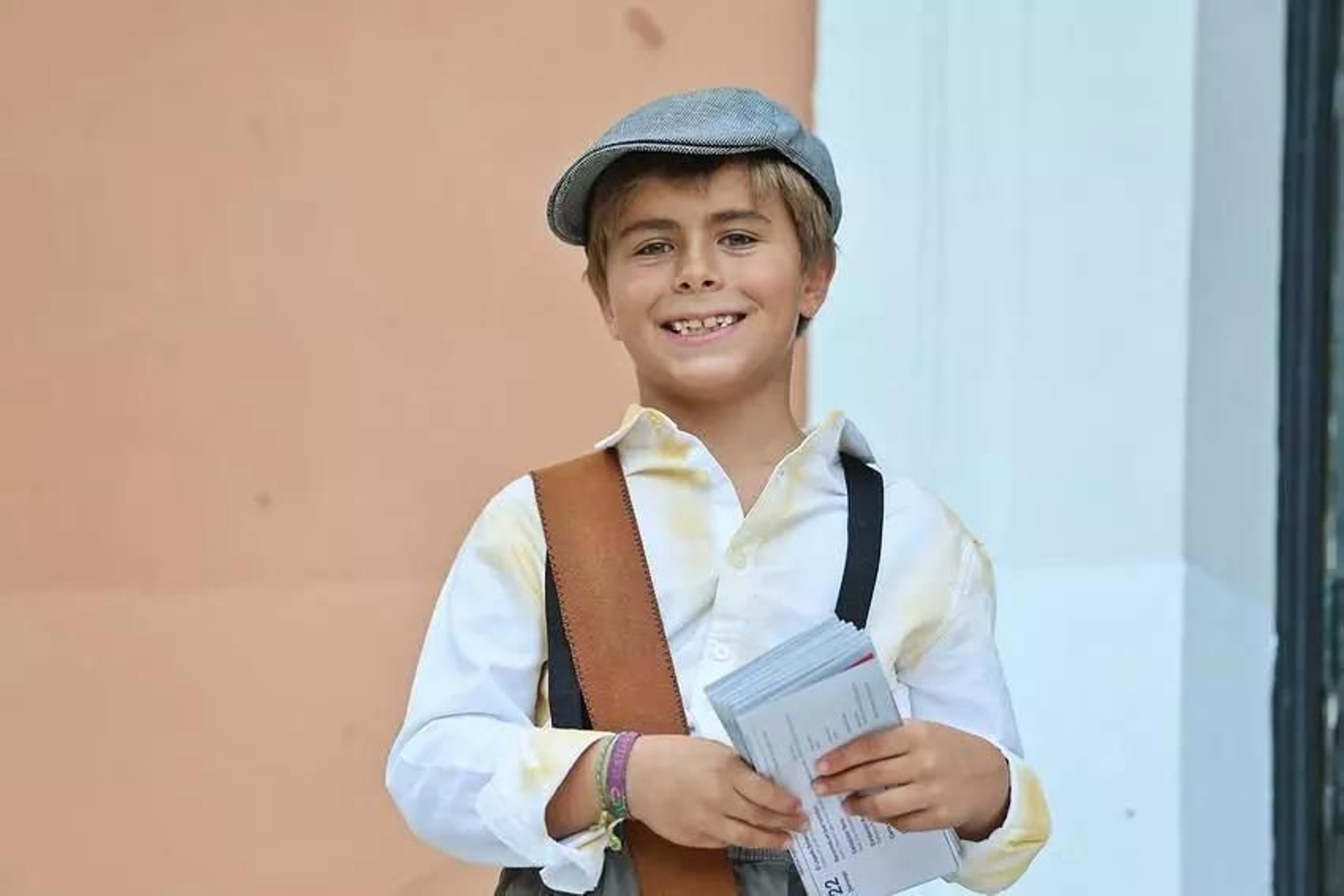 Niño caracterizado como vendedor de periódicos que pregona la Feria del Legado Británico de Huelva estos días.