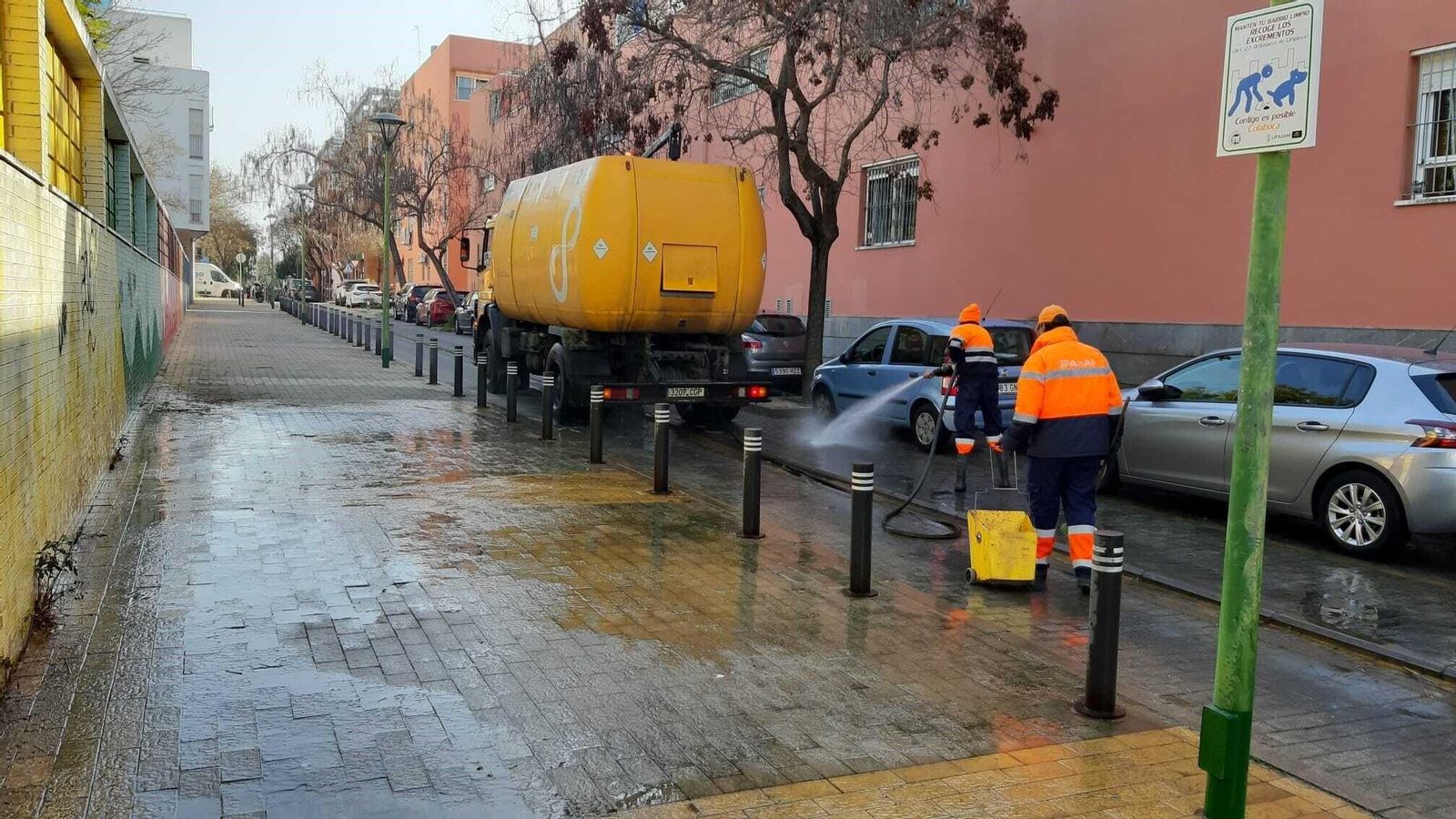 Operarios de Lipasam baldean una calle en los barrios.