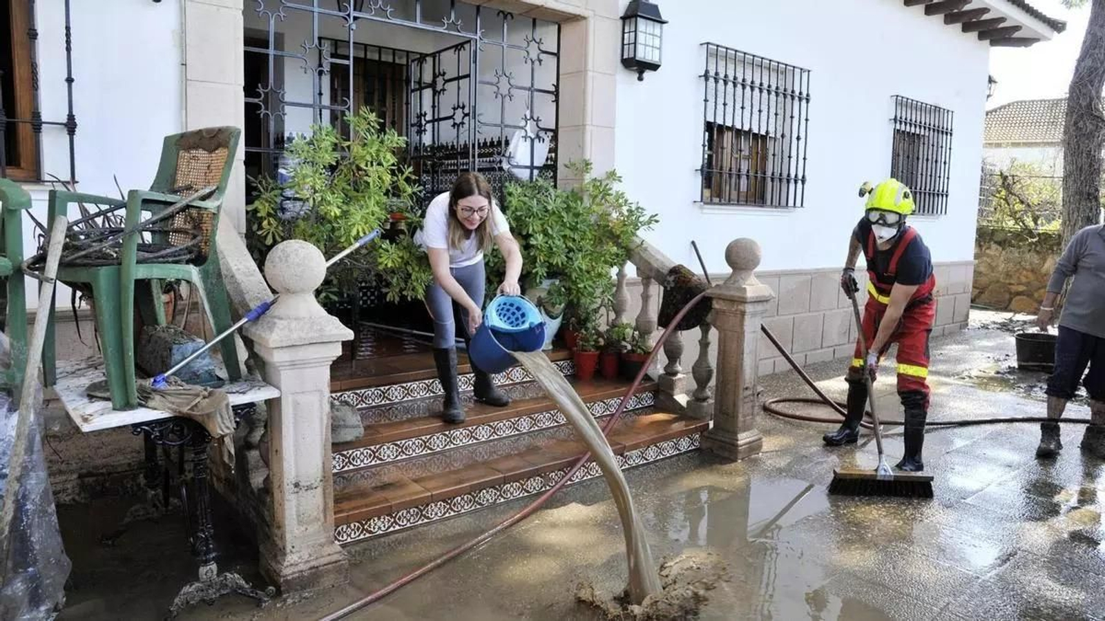 Una mujer sacando agua de su casa en una tromba de agua caída en Setenil hace unos años