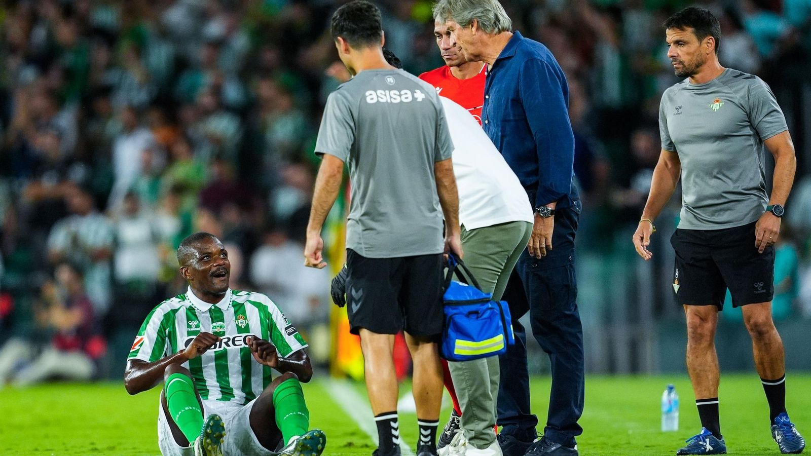 William Carvalho es atendido en el suelo por los médicos del Betis en presencia de Manuel Pellegrini.