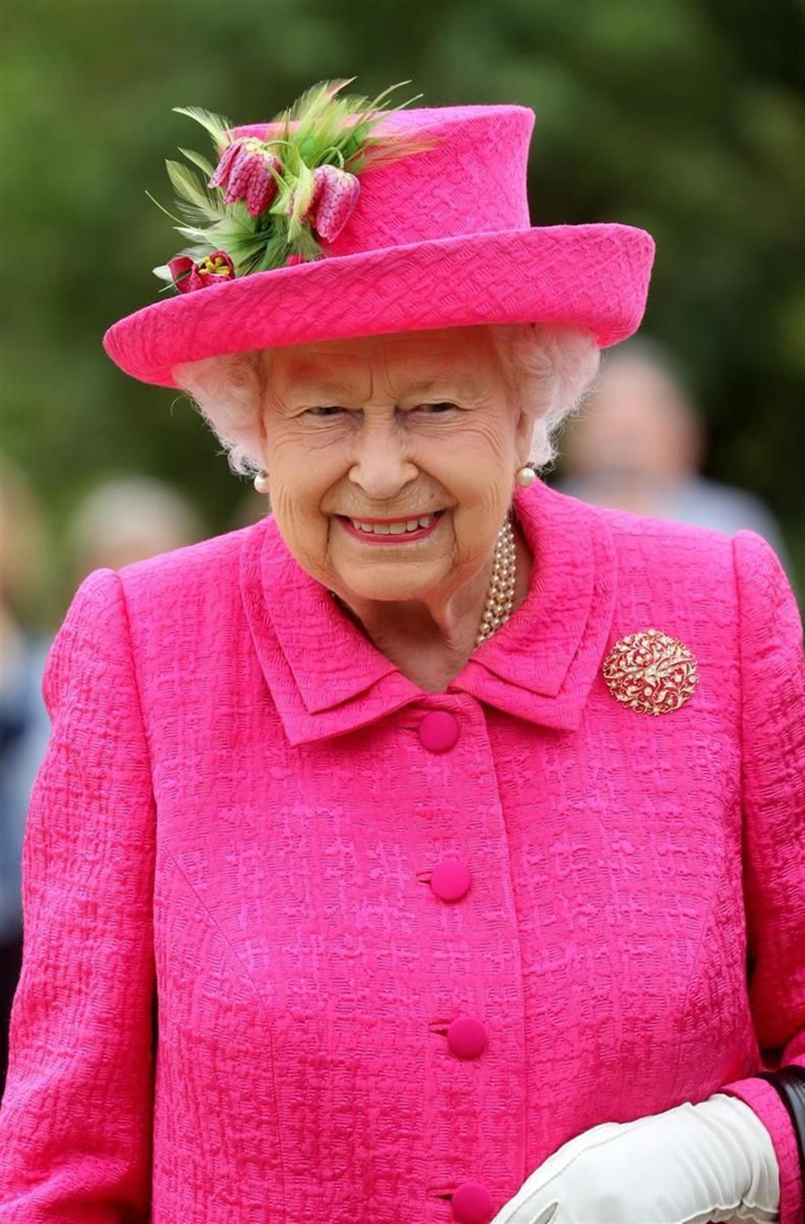 La Reina Isabel II de Inglaterra con un look en rosa fucsia.