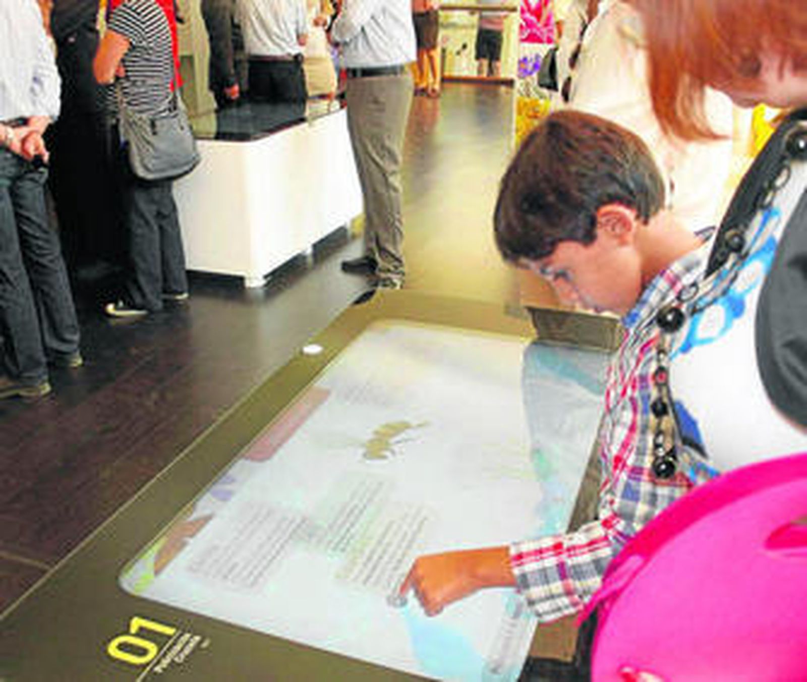 Un niño interactúa con los paneles de información del Museo de la Miel del municipio.